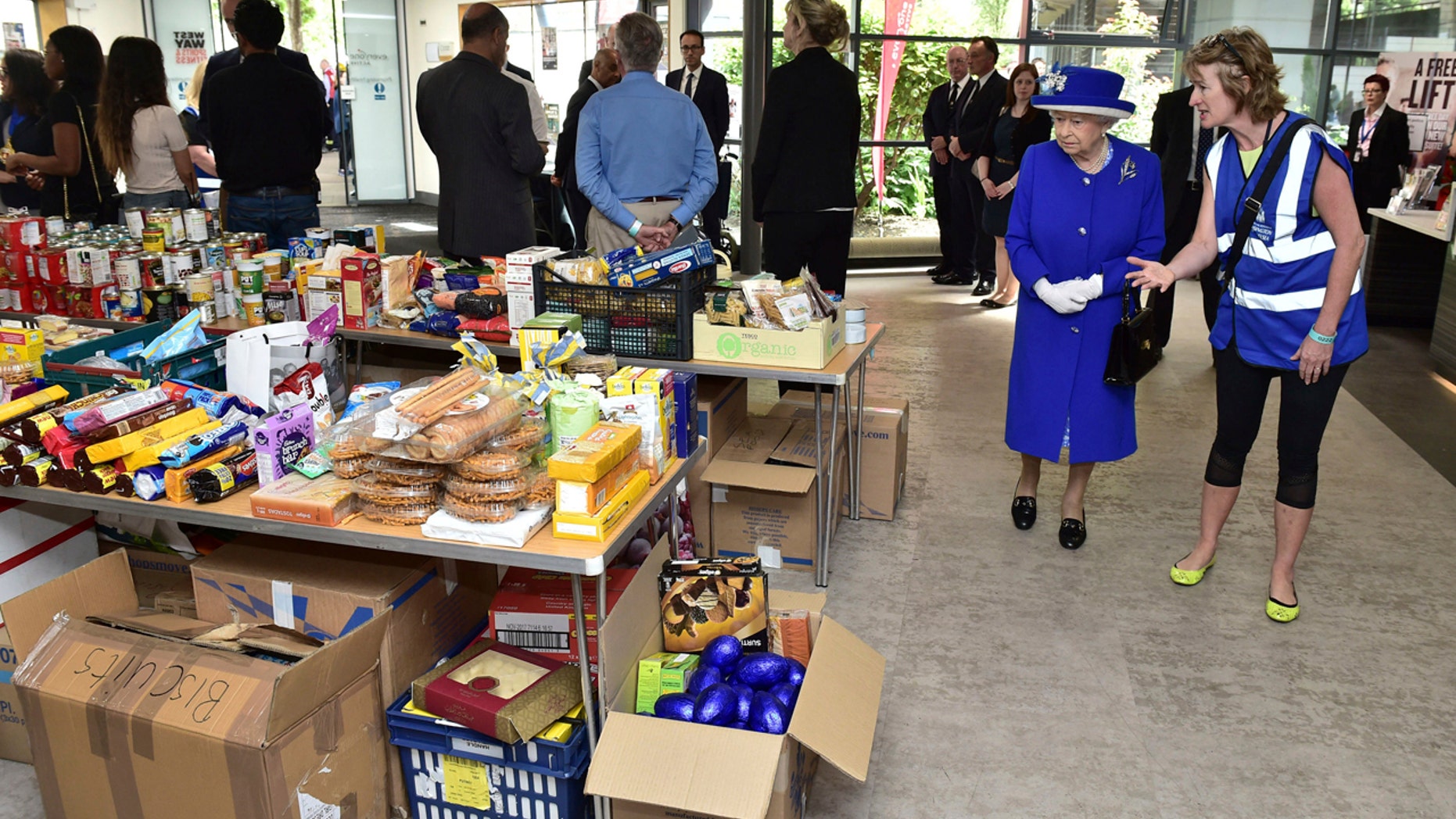 Britain's Queen Elizabeth II, second right, looks at donations made to the members of the community affected by the fire at Grenfell Tower in west London during a visit to the Westway Sports Centre which is providing temporary shelter for those who have been made homeless in the disaster, Friday June 16, 2017.