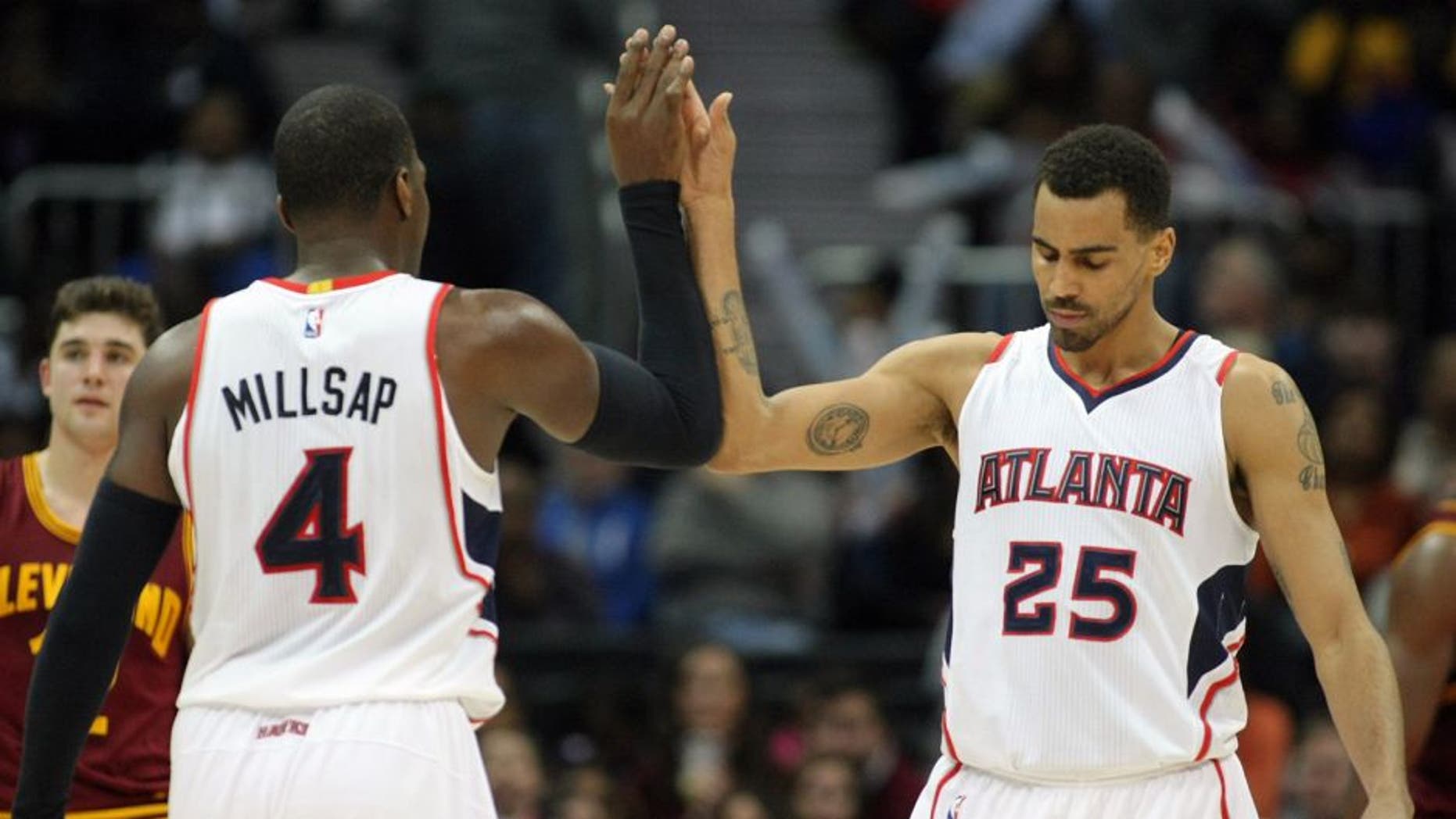 Dec 30, 2014; Atlanta, GA, USA; Atlanta Hawks forward Paul Millsap (4) celebrates with guard Thabo Sefolosha (25) against the Cleveland Cavaliers in the second quarter at Philips Arena. Mandatory Credit: Brett Davis-USA TODAY Sports