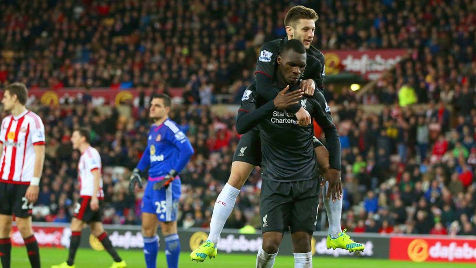 SUNDERLAND, ENGLAND - DECEMBER 30: Christian Benteke of Liverpool celebrates with team-mate Adam Lallana of Liverpool after scoring the opening goal as Sunderland players show their dejection during the Barclays Premier League match between Sunderland and Liverpool at Stadium of Light on December 30, 2015 in Sunderland, England. (Photo by Ian MacNicol/Getty Images)