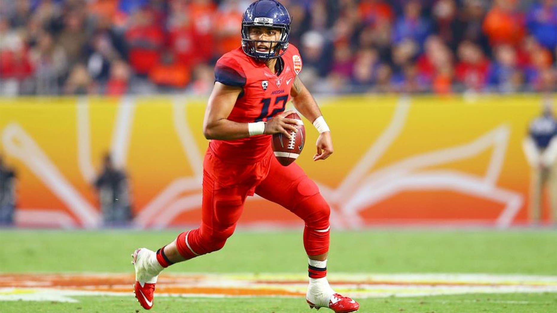 Dec 31, 2014; Glendale, AZ, USA; Arizona Wildcats quarterback Anu Solomon (12) scrambles in the second quarter against the Boise State Broncos in the 2014 Fiesta Bowl at Phoenix Stadium. Mandatory Credit: Mark J. Rebilas-USA TODAY Sports