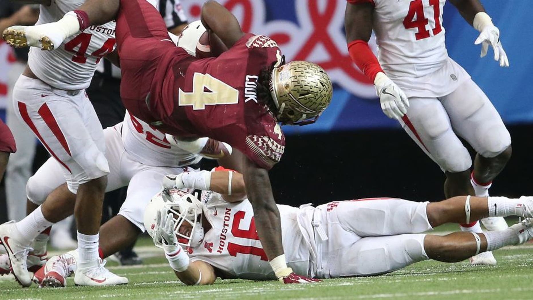 Florida State running back Dalvin Cook (4) falls as Houston safety Adrian McDonald (16) looks on during the second half of the Peach Bowl NCAA college football game, Thursday, Dec. 31, 2015, in Atlanta. (AP Photo/John Bazemore)
