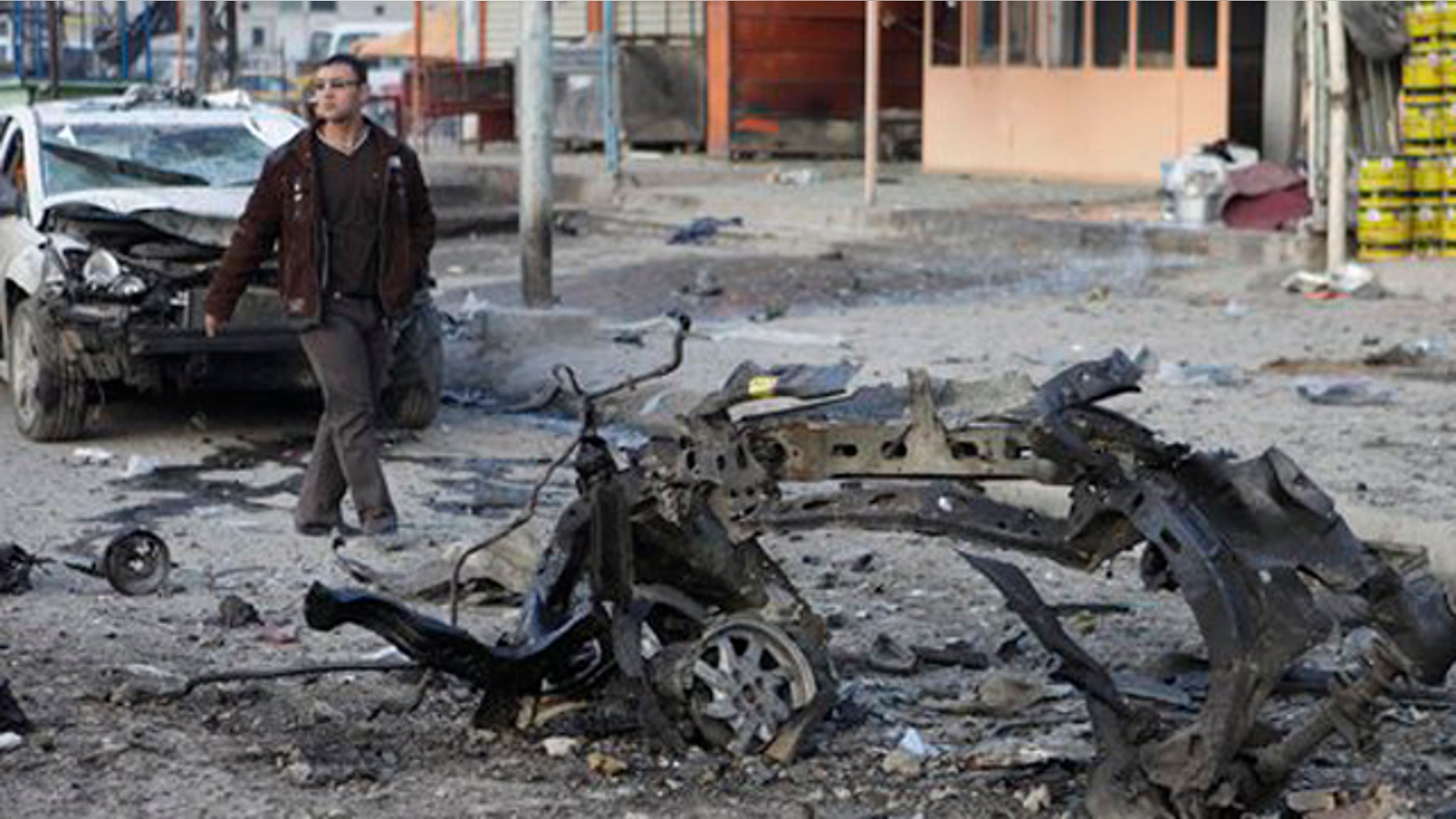 Jan. 24, 2012: A man inspects the scene of a car bomb attack in Sadr City eastern of Baghdad, Iraq.