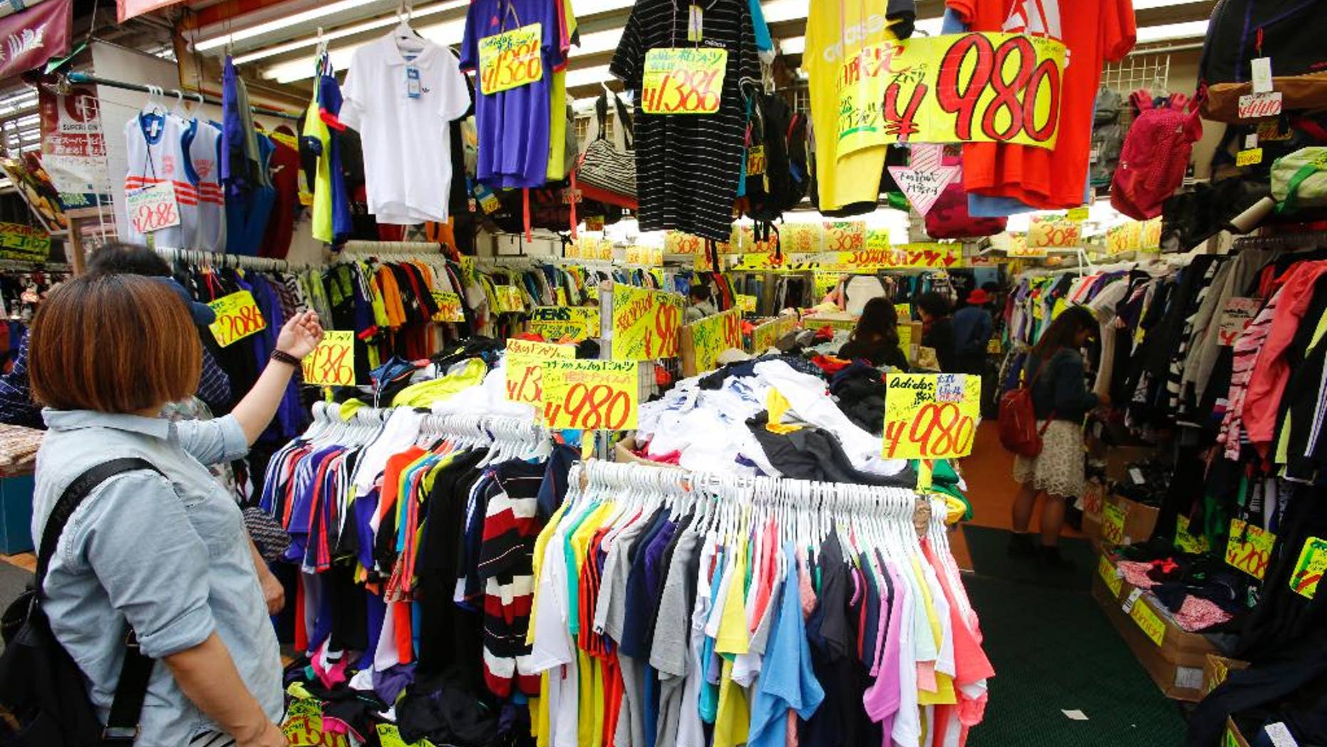 In this May 16, 2016 photo, shoppers choose clothes at Ameyoko shopping district in Tokyo. Japan reports its economy grew at a better than expected 1.7 percent annual pace in March, as higher government outlays helped offset weakness in business investment and exports. The Cabinet Office reported Wednesday, May 18 that the quarterly pace of GDP growth for the world's third-largest economy was 0.4 percent. (AP Photo/Shizuo Kambayashi)