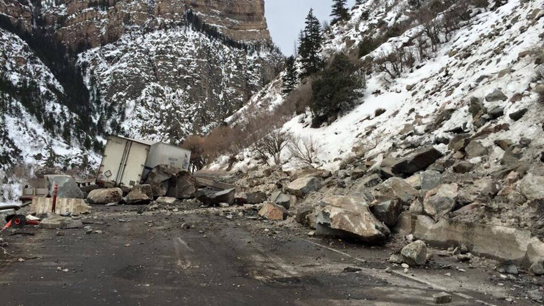 In this Tuesday, Feb. 16, 2016, photo provided by the Colorado Department of Transportation, state highway workers examine debris from a Monday rock slide on Interstate 70 in Glenwood Canyon in western Colorado.
