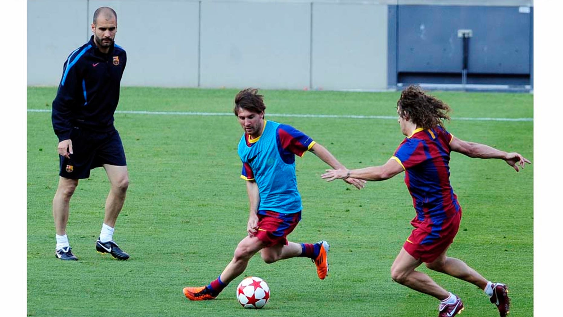 FC Barcelona's coach Pep Guardiola, left, Lionel Messi, from Argentina, center, and Carles Puyol attend a training session at the Camp Nou stadium in Barcelona, Spain, Monday, May 23, 2011. FC Barcelona will play against Manchester United in the final of the Champions League at Wembley stadium in London on May 28. (AP Photo/Manu Fernandez)