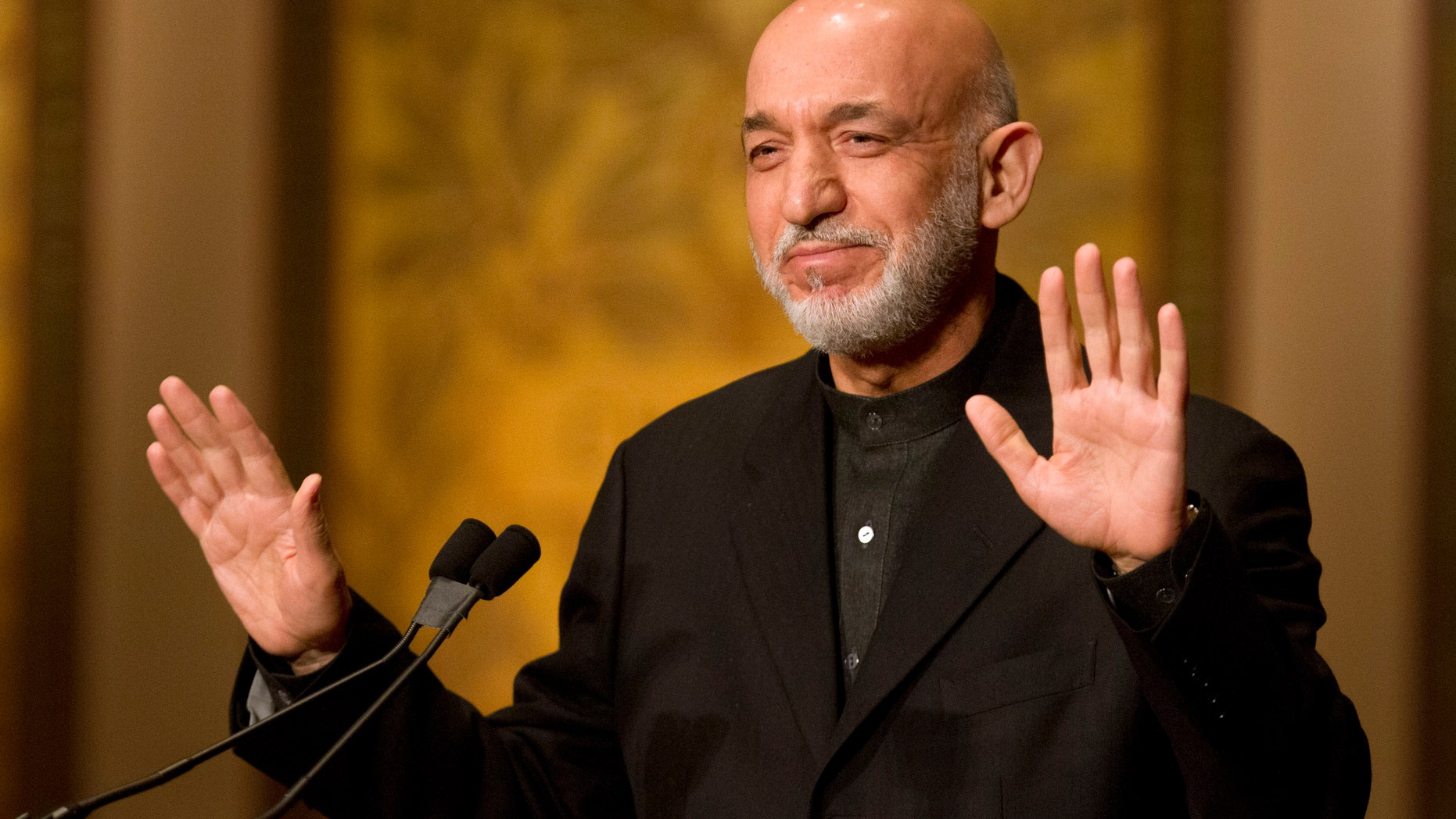 Afghanistan President Hamid Karzai gestures for applause to stop before he began his speech at Georgetown University in Washington, Friday, Jan. 11, 2013. (AP Photo/Jacquelyn Martin)