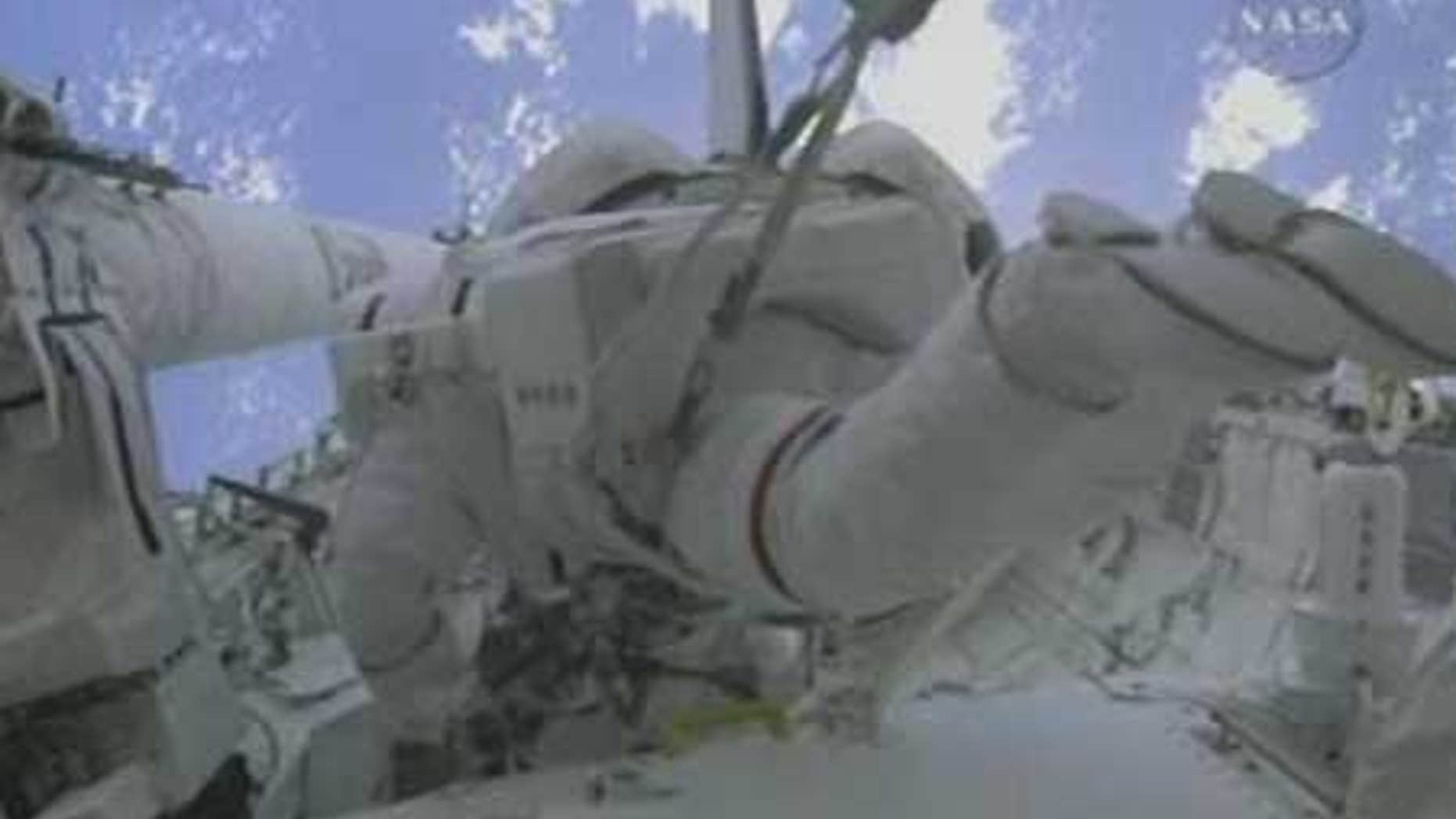 Spacewalkers Mike Foreman and Bobby Satcher at work outside the International Space Station