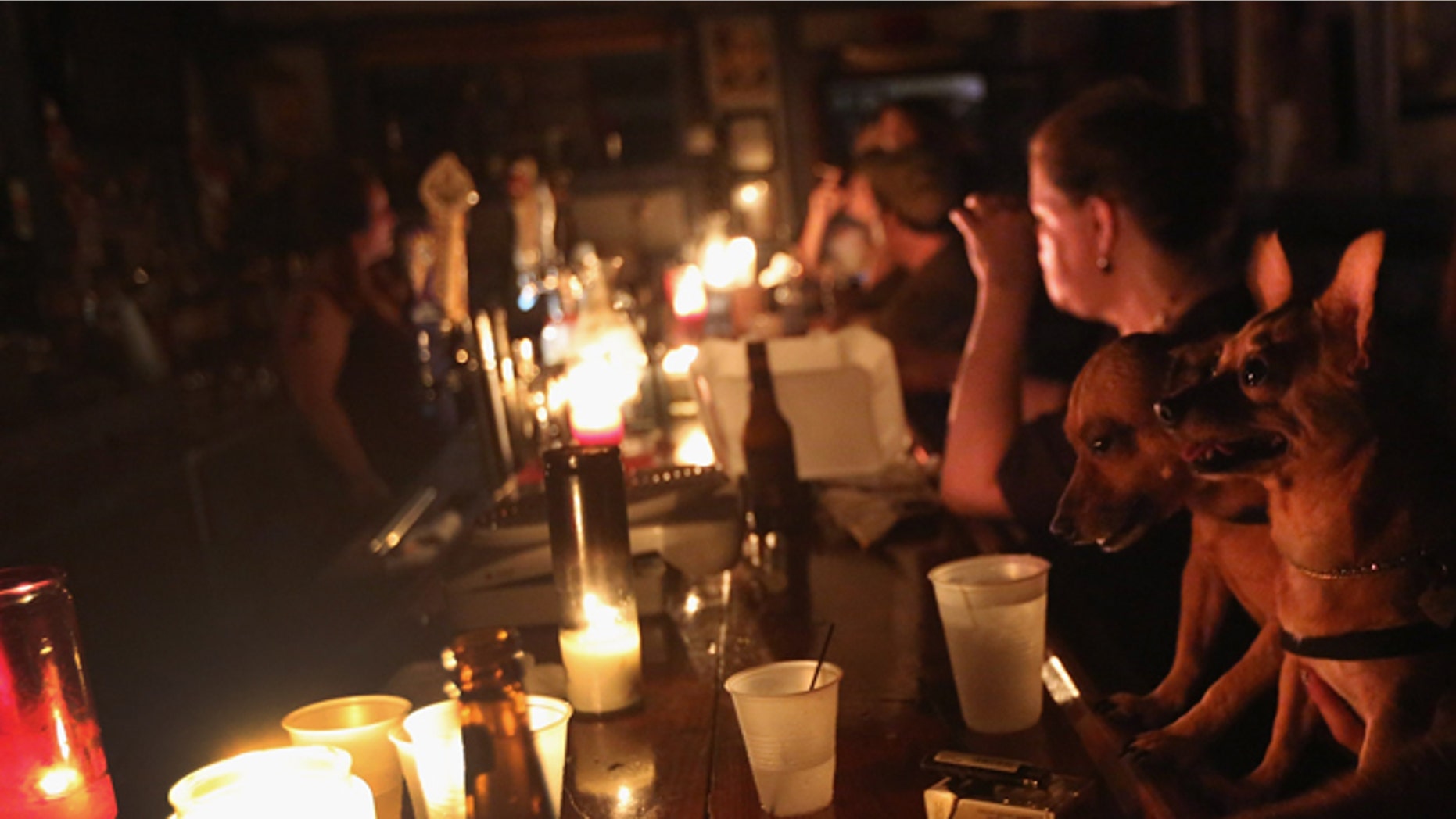 NEW ORLEANS, LA - AUGUST 31: Local residents drink by candle light at JJ's bar during the continued blackout on August 31, 2012 in the Bywater neighborhood of New Orleans, Louisiana. The area was still without electricity three days after Hurricane Isaac knocked out power to hundreds of thousands of people. (Photo by John Moore/Getty Images)