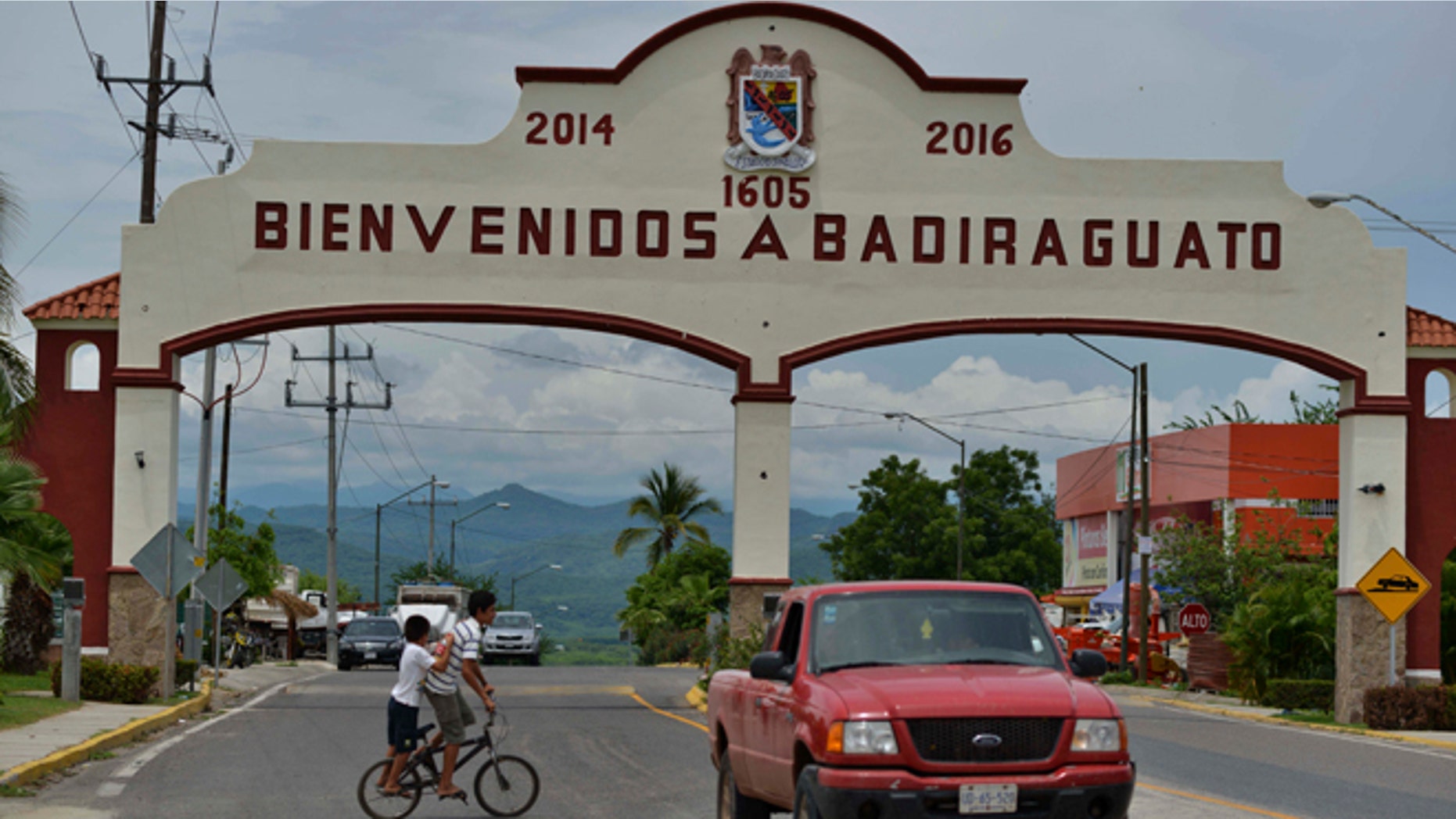 In this July 20, 2015 photo, a car drives past the entrance to the town of Badiraguato, Mexico.