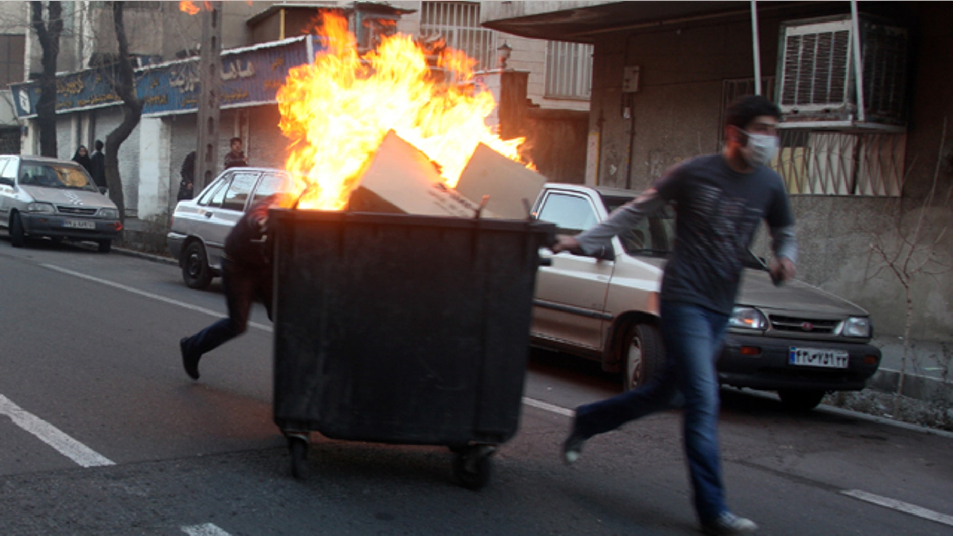 Feb. 14: This photo, taken by an individual not employed by the Associated Press and obtained by the AP outside Iran, shows Iranian protestors moving a garbage can which is set on fire during an anti-government protest in Tehran, Iran.