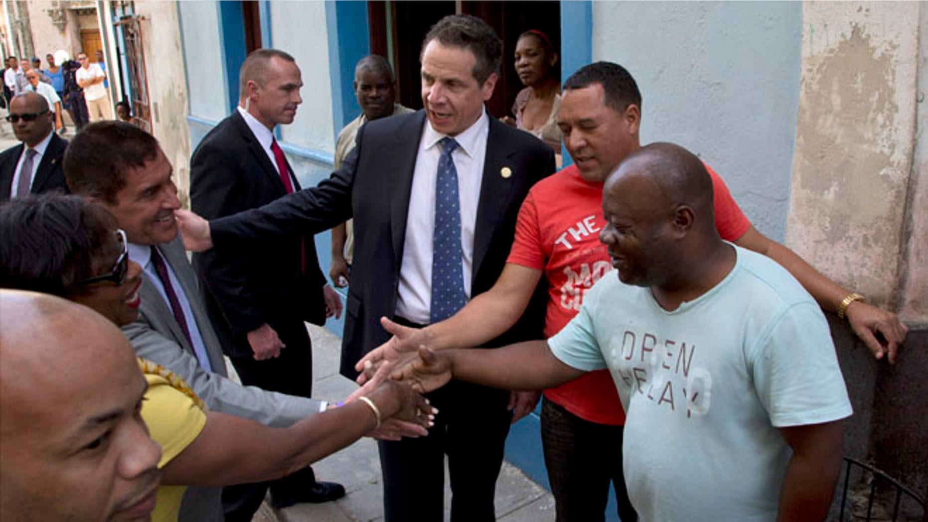 New York Governor Andrew Cuomo, center, greets people on a street in old Havana, Cuba, Monday, April 20, 2015. The formal state visit, a trip that makes Cuomo the first American governor to visit the island since the recent thaw in relations with the communist nation, is meant to foster greater ties between New York and Cuba. (AP Photo/Ramon Espinosa)