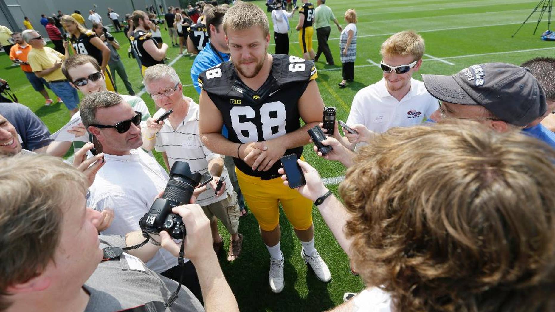 Iowa offensive linesman Brandon Scherff (68) speaks to the media during Iowa's annual college football media day, Monday, Aug. 4, 2014, in Iowa City, Iowa. (AP Photo/Charlie Neibergall)