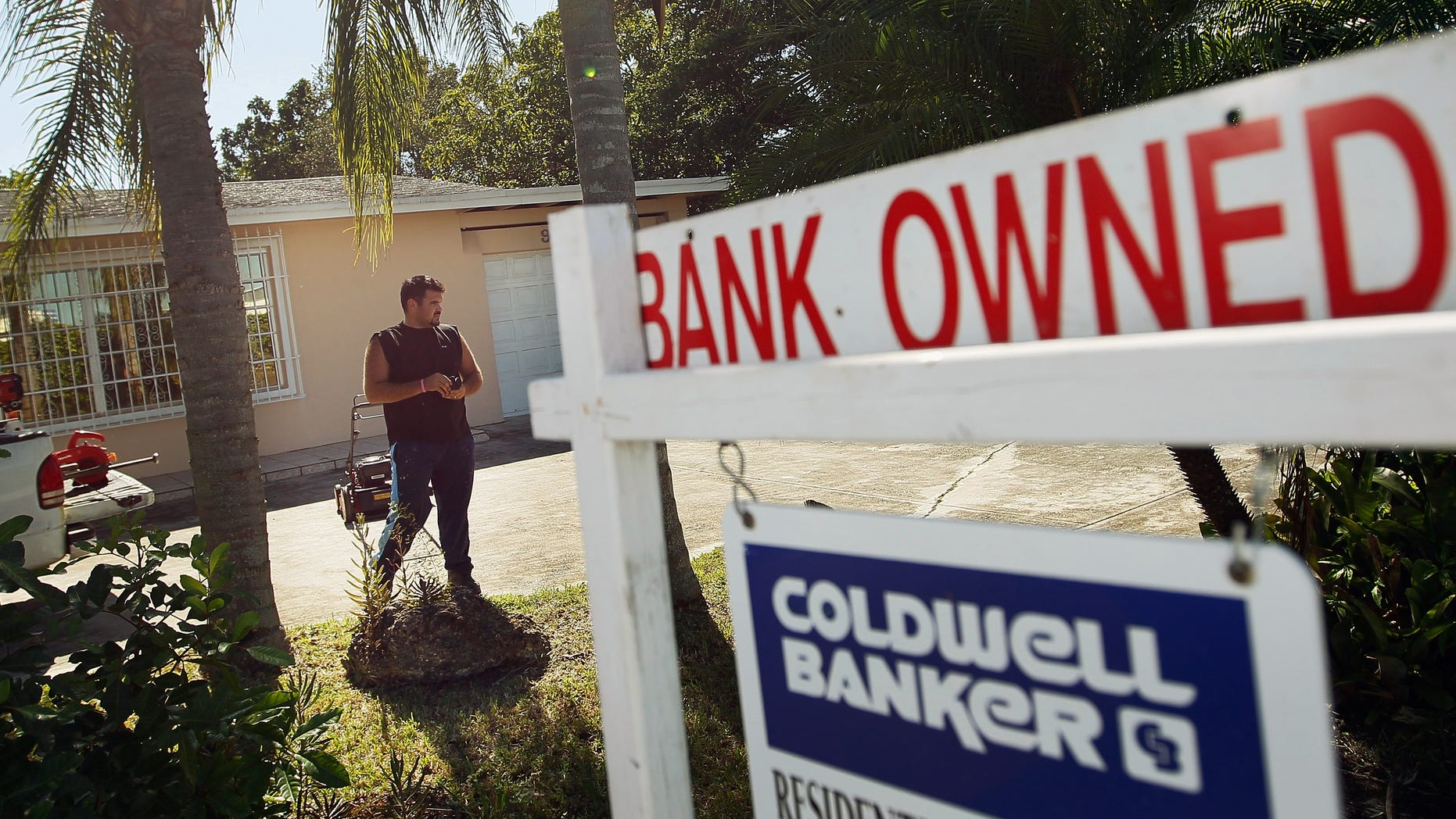 MIAMI, FL - NOVEMBER 10: Renzo Salazar maintains the yard around a foreclosed home after the bank hired him to keep the home from falling into complete dilapidation on November 10, 2011 in Miami, Florida. RealtyTrac reported that foreclosures were up 7 percent in October from the prior month as defaults in California, Florida and Michigan hit 12-month highs. (Photo by Joe Raedle/Getty Images)