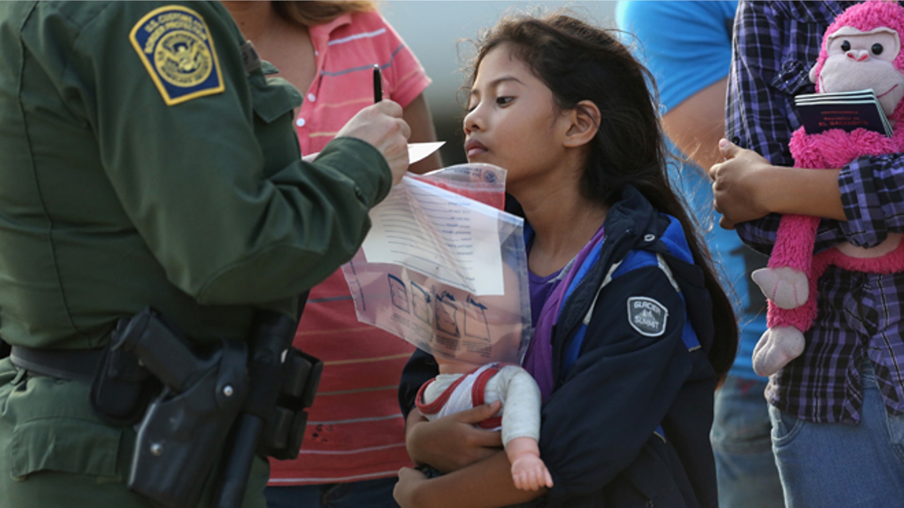 Salvadorian immigrant Stefany Marjorie, 8, watches as a U.S. Border Patrol agent records family information.