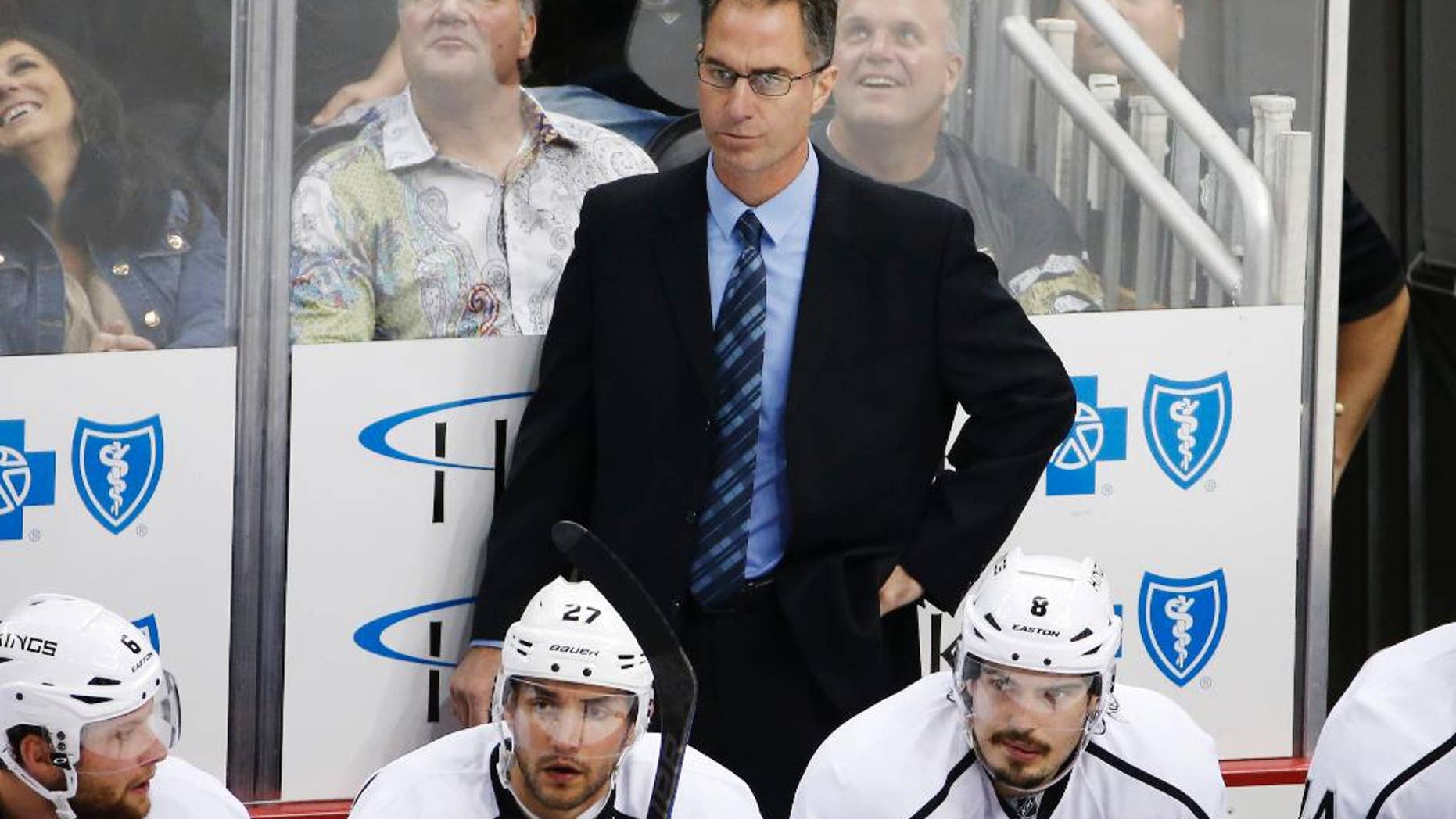 FILE - In this Thursday, Oct. 30, 2014, file photo, Los Angeles Kings assistant coach John Stevens stands behind his bench during the first period of an NHL hockey game against the Pittsburgh Penguins in Pittsburgh. A person with direct knowledge of the situation tells The Associated Press that the Los Angeles Kings will name Stevens their next head coach. Stevens replaces Darryl Sutter after serving as a Kings assistant and then associate coach for the past eight seasons, which included two Stanley Cups. (AP Photo/Gene J. Puskar, File)