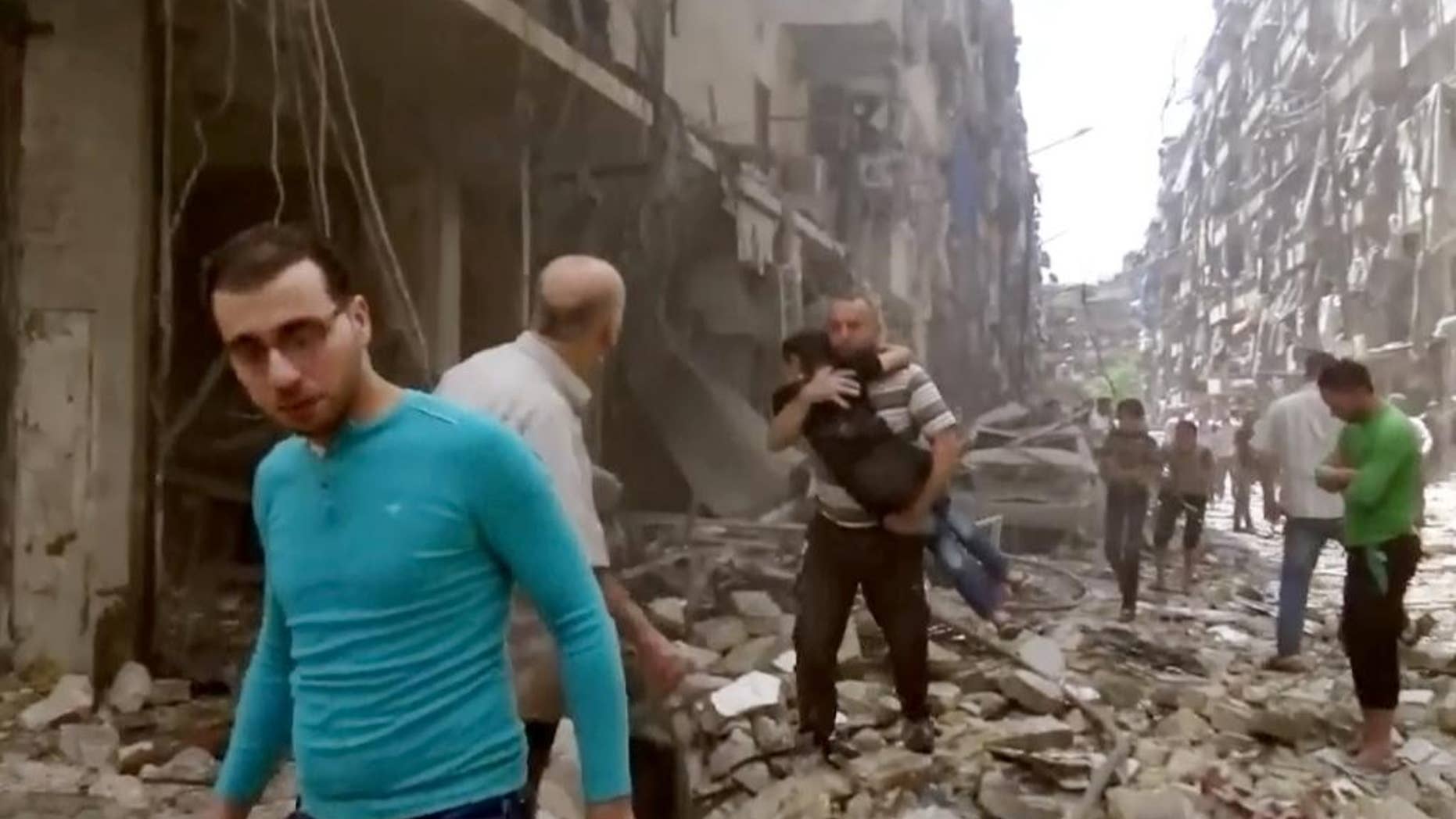 FILE - In this Thursday, April 28, 2016 image made from video and posted online from Validated UGC, a man carries a child after airstrikes hit Aleppo, Syria. A fragile cease-fire in the northern Syrian city of Aleppo has been extended for 72 hours, Russia said, as the Islamic State group battled other militant factions near the city on Saturday, May 7, 2016. (Validated UGC via AP video, File)