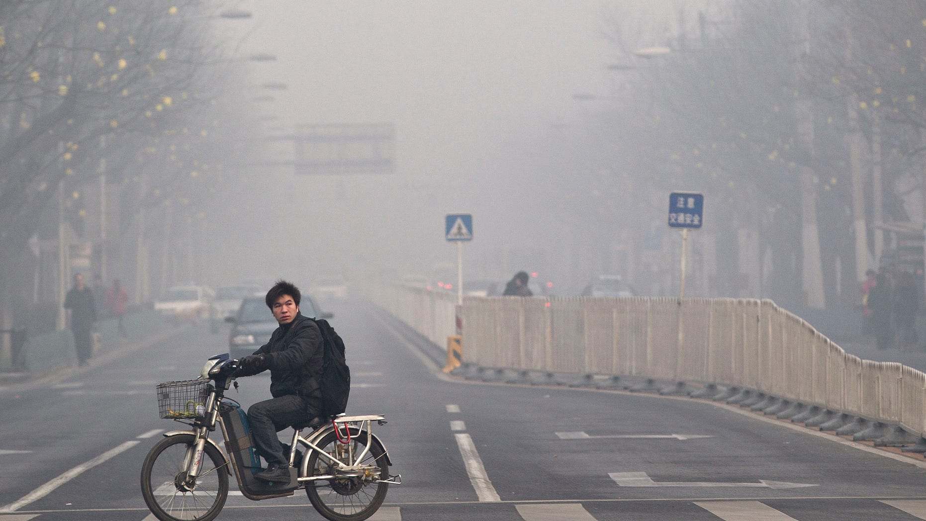 Jan. 10, 2012: A man rides an electric bike crossing a street shrouded by haze in Beijing. A senior Chinese environmental official told foreign embassies on Tuesday, June 5, 2012 to stop publishing their own reports on air quality in China, a clear reference to a popular U.S. Embassy Twitter feed that tracks pollution in smoggy Beijing.