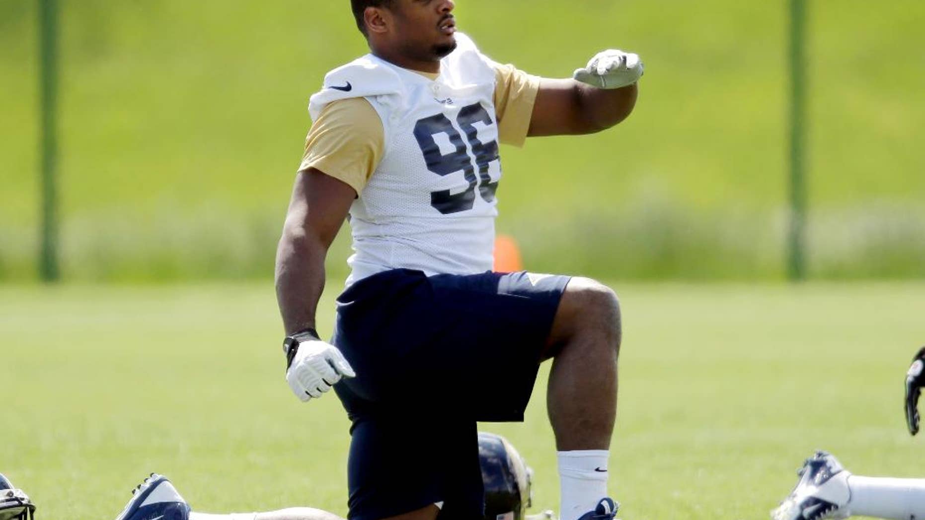 St. Louis Rams rookie defensive end Michael Sam stretches during the team's NFL football rookie camp Friday, May 16, 2014, in St. Louis. (AP Photo/Jeff Roberson)