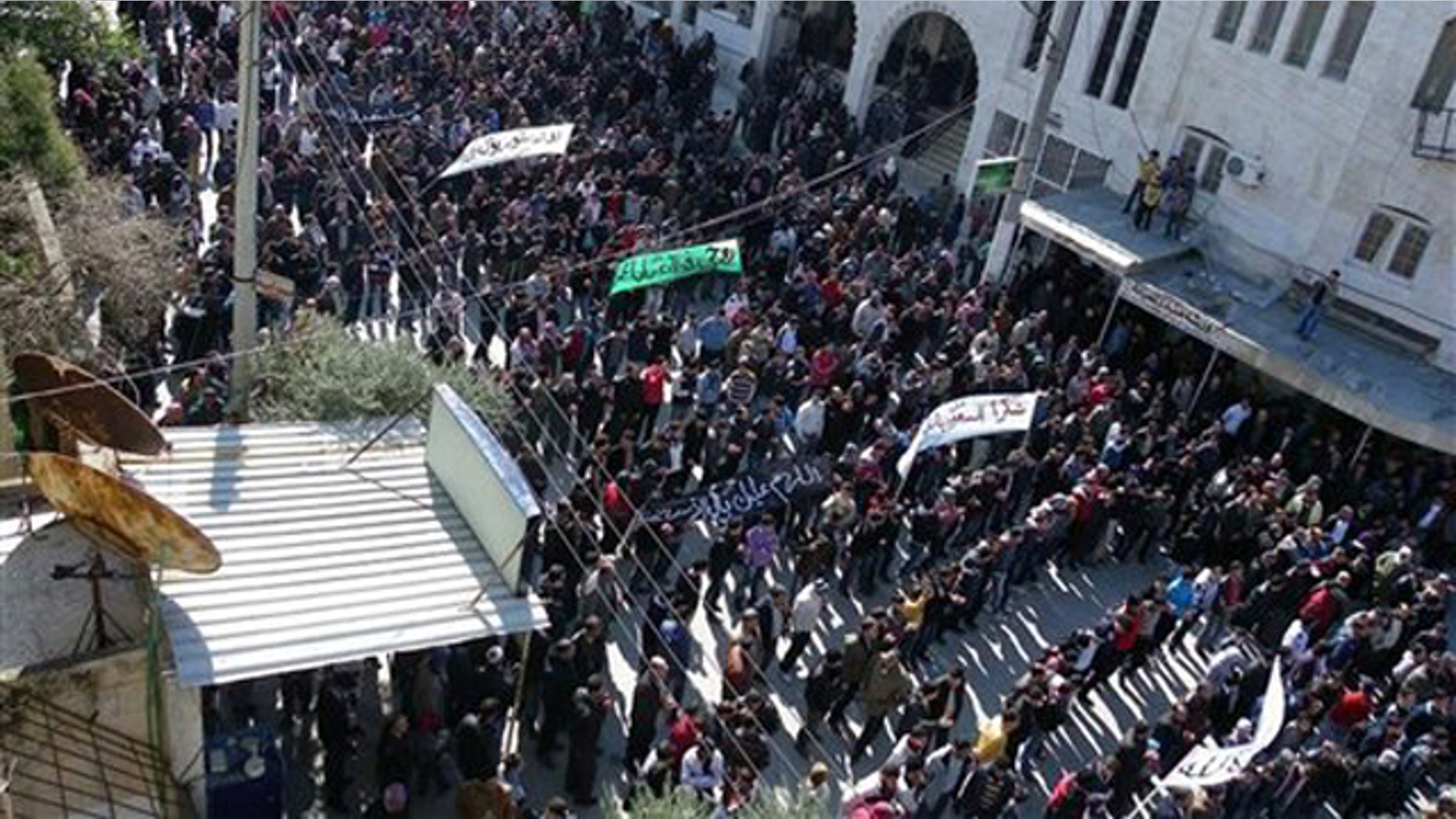 March 2, 2012: Anti-Syrian regime protesters hold up banners during a demonstration in Idlib, Syria.