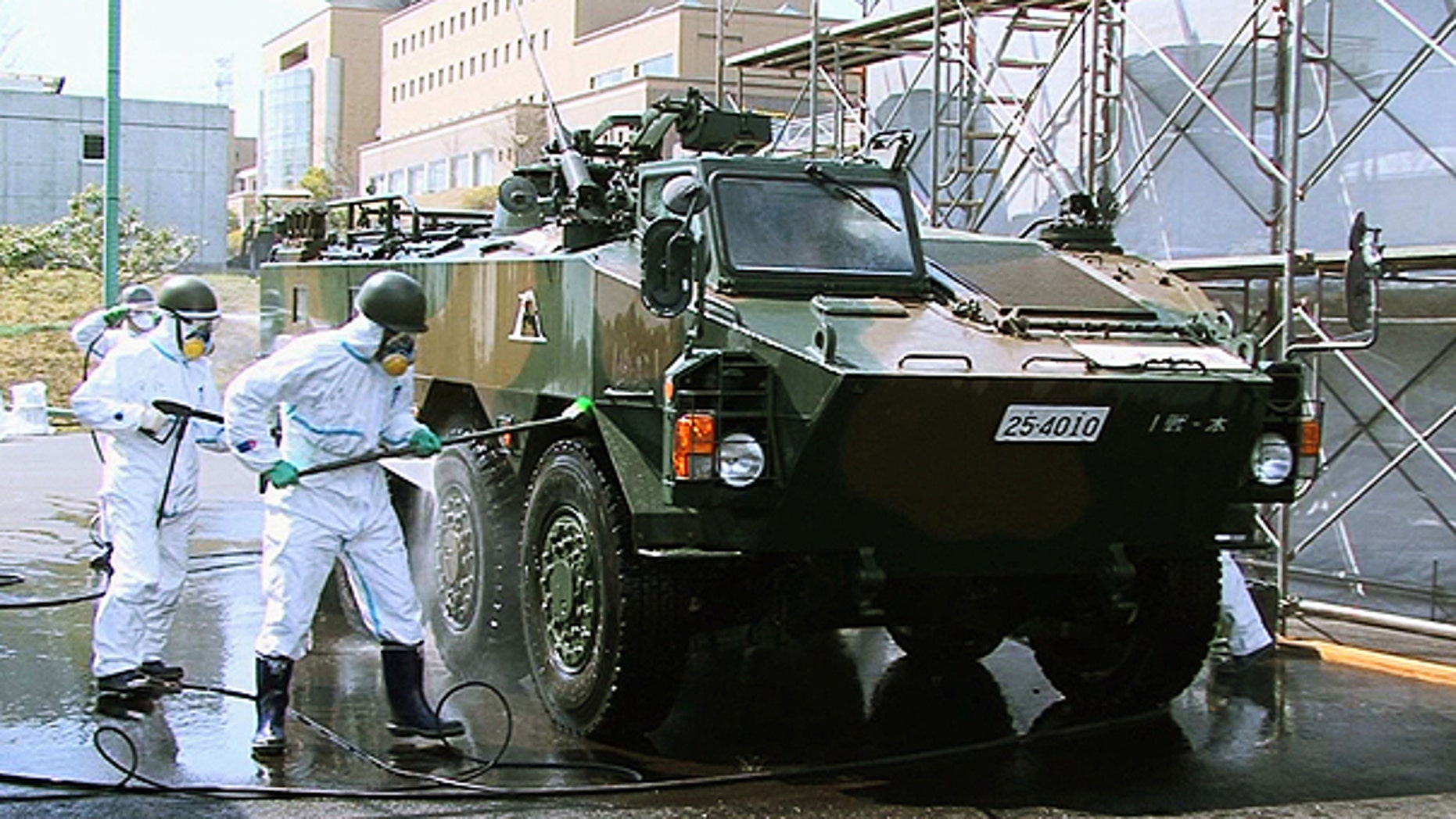 April 12: In this photo released by the Japan Defense Agency via Kyodo News, Japanese soldiers wash an armored vehicle to remove potential radiation contamination at J-Village, a soccer training complex now serving as an operation base for those battling Japan's worst nuclear disaster, northeastern Japan.