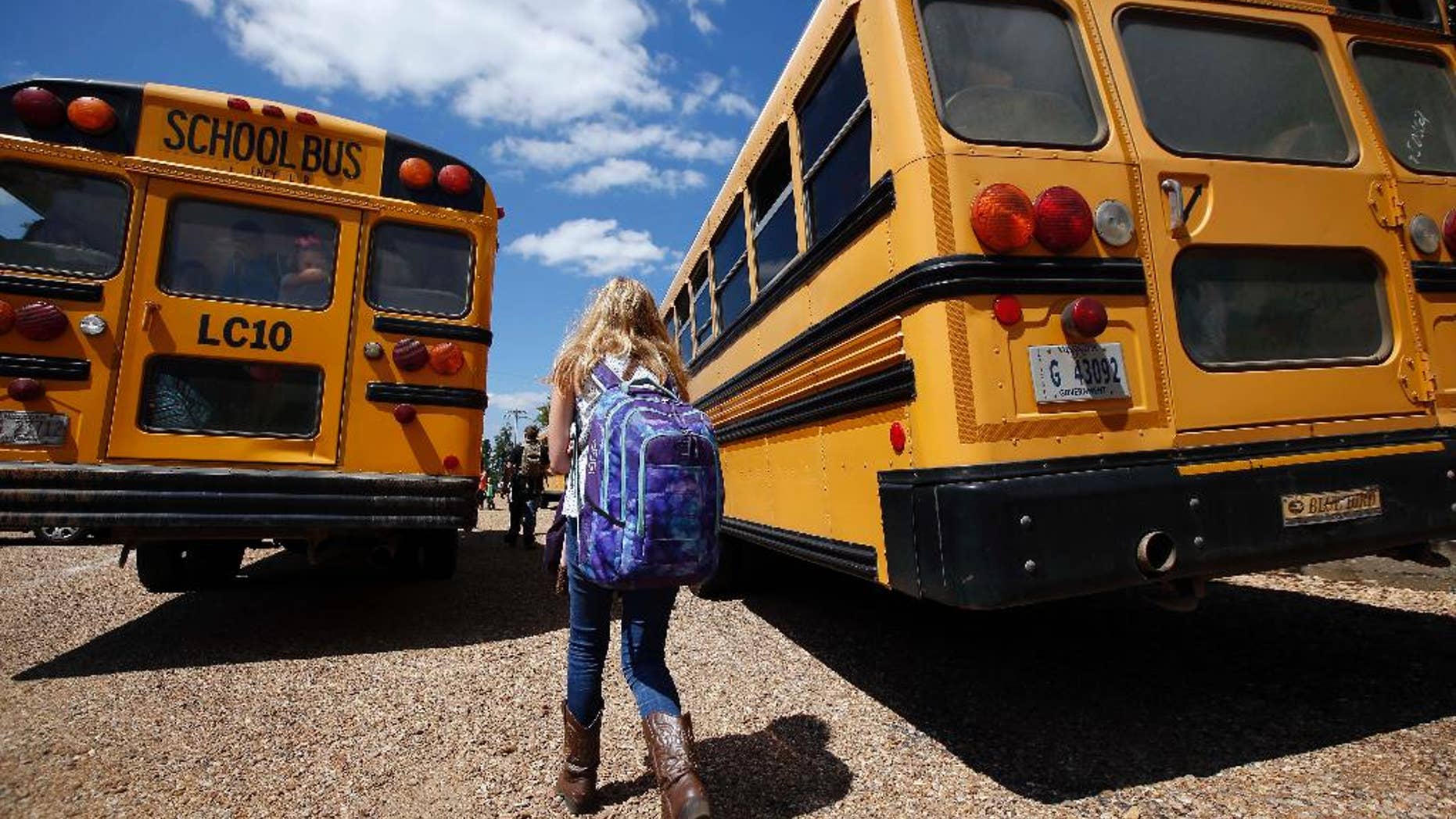 FILE - In this Aug. 13, 2014 file photo, a student prepares to leave the Enterprise Attendance Center, southeast of Brookhaven Miss. Much can go unsaid between parents and teachers due to lack of time and opportunity, or the tender nature of some issues. Some teachers say they'd like parents to know how much home life bleeds into school. And they say they welcome more communication and trust. (AP Photo/Rogelio V. Solis, File)
