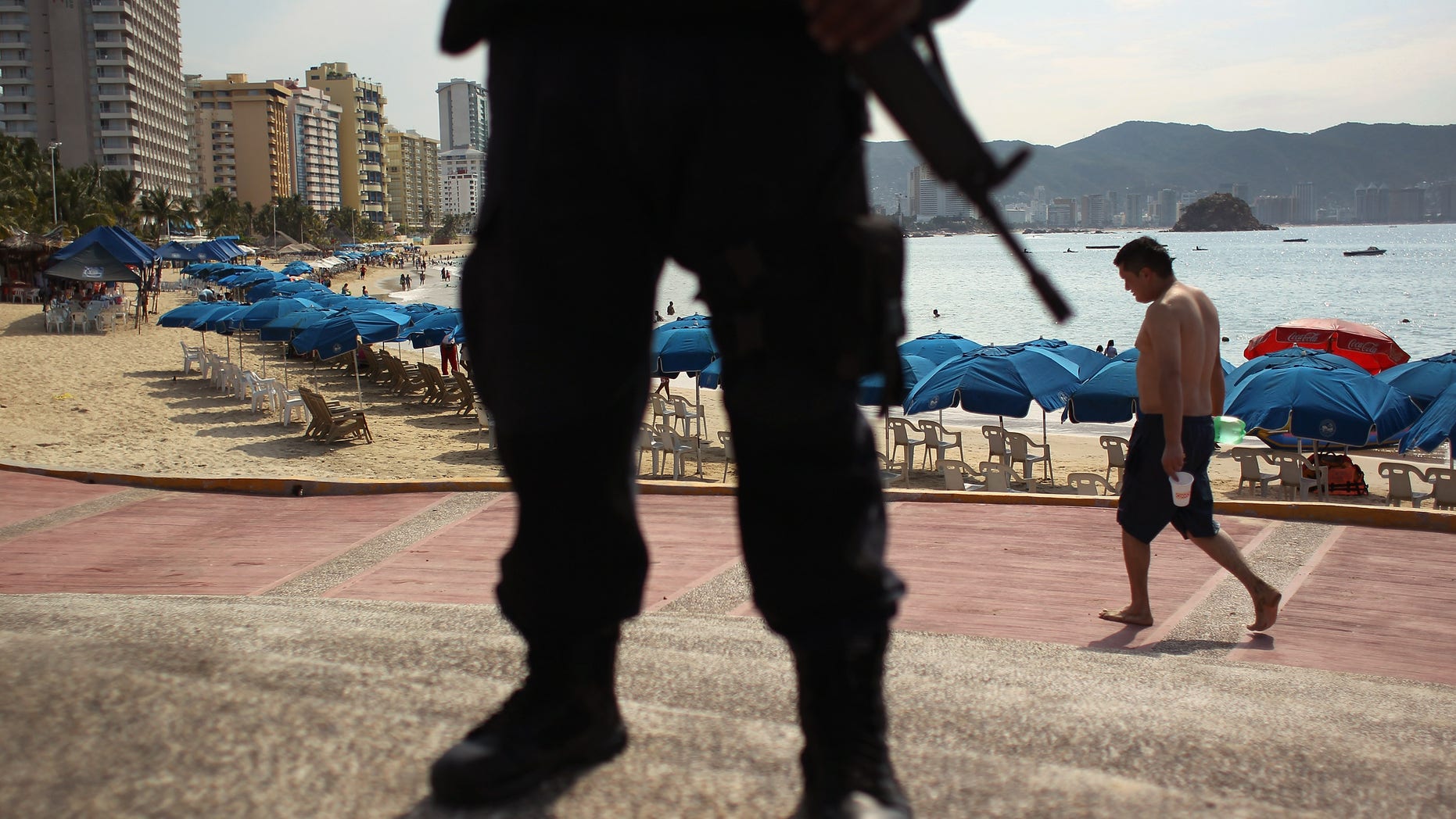 A Mexican federal policeman stands guard near the beach in Acapulco, Mexico.