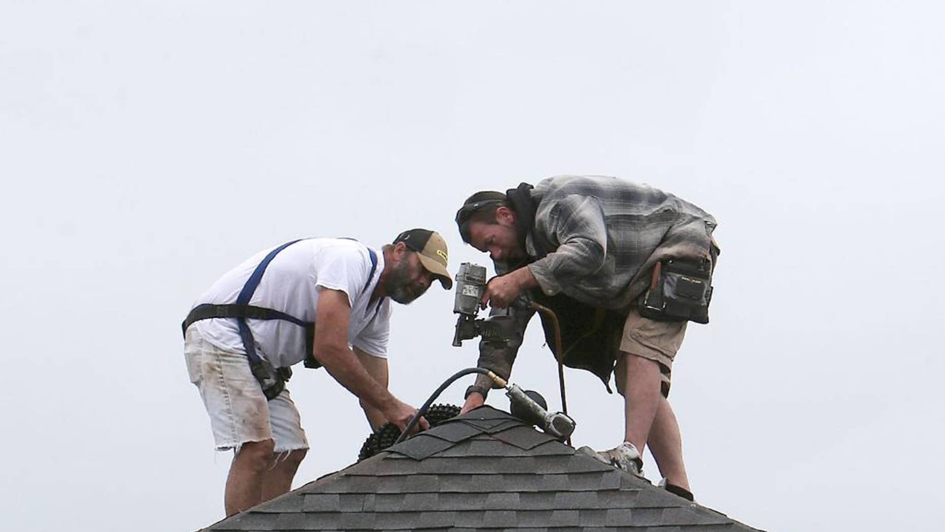 In this March 24, 2015 photo, roofers work on a new home in Panama City, Fla. The Federal Reserve releases its Beige Book report on Wednesday, April 15, 2015. (Andrew Wardlow/News Herald via AP)