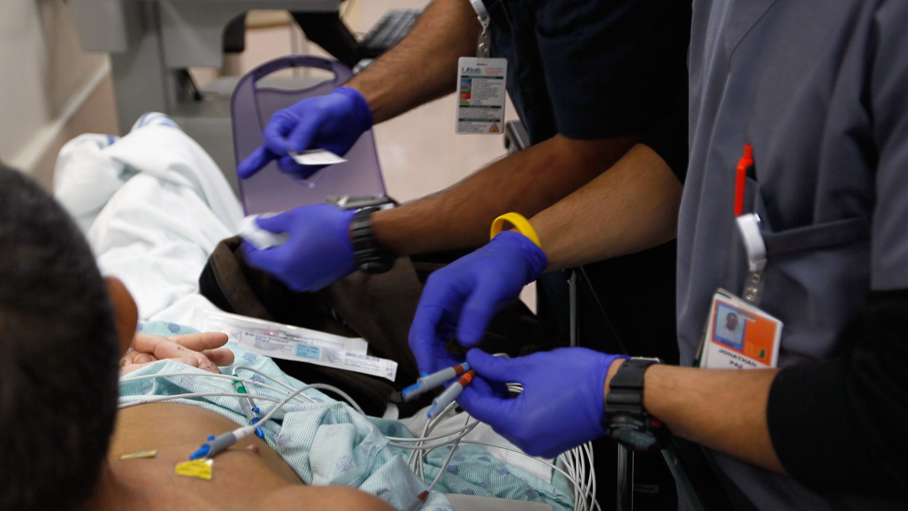 MIAMI, FL - APRIL 30: Paramedics Bruno Fernandini (L) and Jonathan Paz hook a patient up to an EKG machine at the University of Miami Hospital's Emergency Department on April 30, 2012 in Miami, Florida. As people wait to hear from the United States Supreme Court on its decision of the constitutionality of the Affordable Care Act, some experts say that if the act is overturned, a decision expected later this year, people that now have insurance will no longer be eligible and will be kicked back into a system where the emergency department is their first visit when sick. (Photo by Joe Raedle/Getty Images)