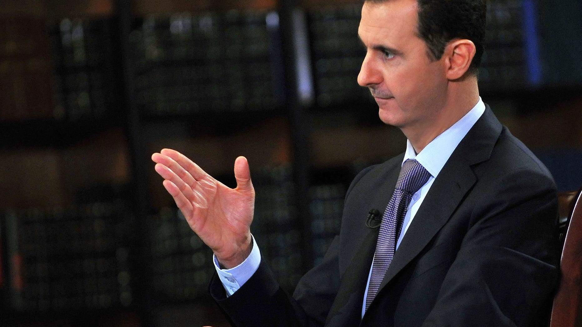 In this photo, which AP obtained from Syrian official news agency SANA, has been authenticated based on its contents and other AP reporting, President Bashar Assad gestures as he speaks during an interview with Italy's RAI News 24 TV, at the presidential palace in Damascus, Syria, Sunday, Sept. 29, 2013. Assad says his government will abide by last week's U.N. resolution calling for the country's chemical weapons program to be dismantled and destroyed. (AP Photo/SANA)