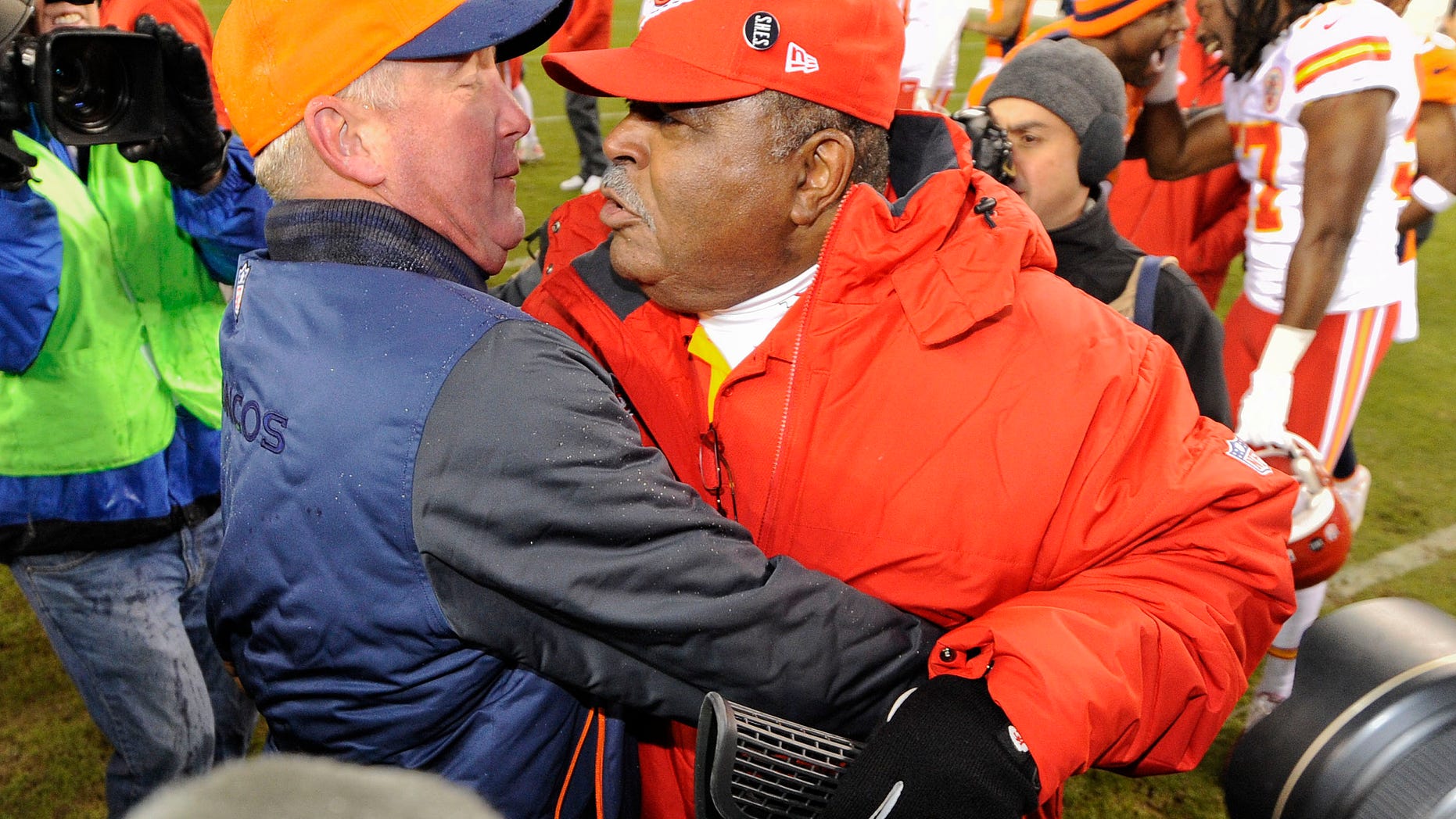 Denver Broncos head coach John Fox, left, greets Kansas City Chiefs coach Romeo Crennel at the end of an NFL football game, Sunday, Dec. 30, 2012, in Denver. Denver won 38-3. (AP Photo/Jack Dempsey)