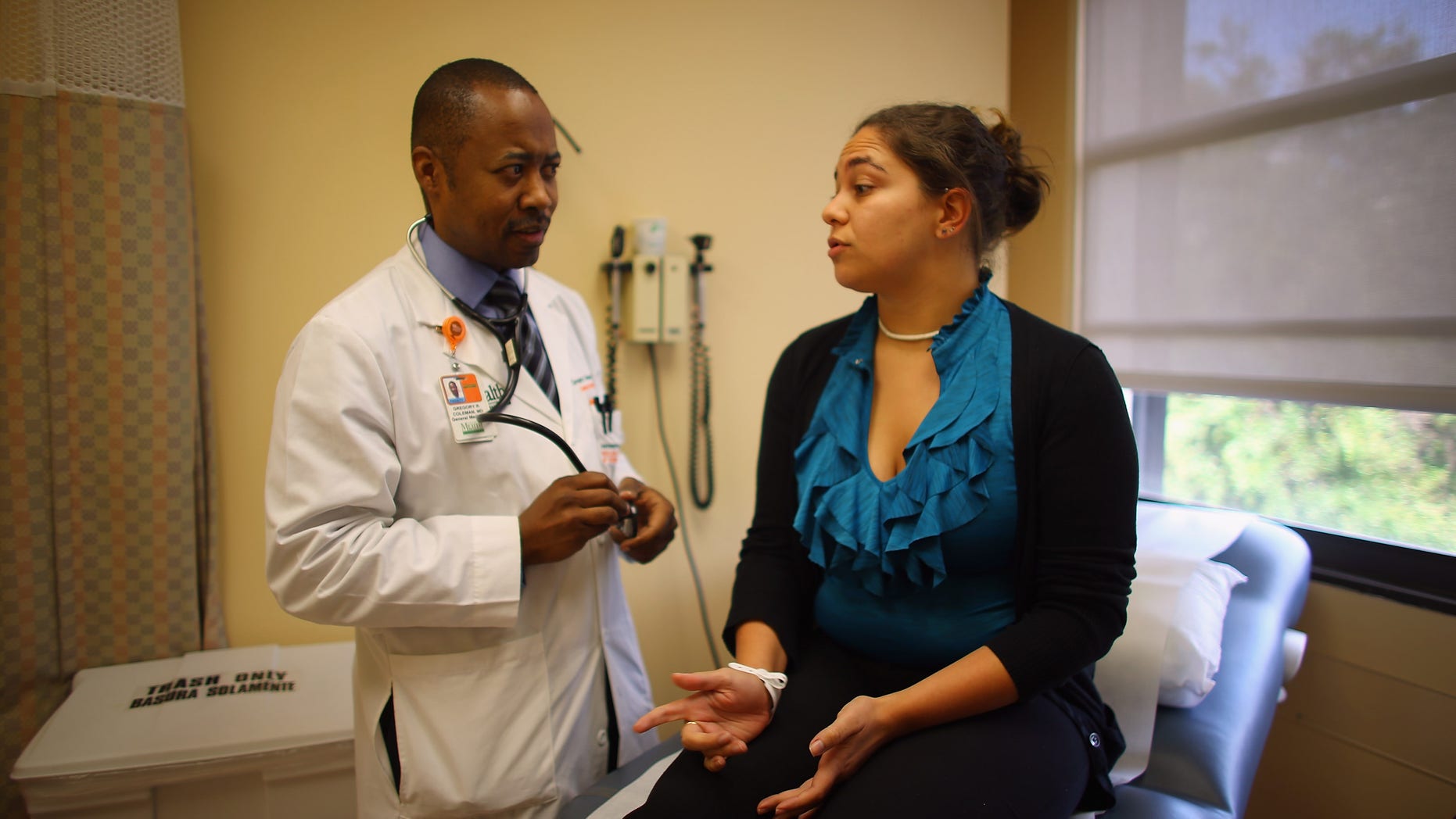 MIAMI, FL - JUNE 28: Dr. Gregory Coleman, Assistant Professor of Medicine, University of Miami, Miller School of Medicine, speaks with Vanessa Moreno, 25 years old, as she visits him for a check-up on the same day that the United States Supreme Court upheld the Affordable Care Act on June 28, 2012 in Miami, Florida. Dr. Coleman said, ?the ruling is a good start to begin to control the economics of medicine?. (Photo by Joe Raedle/Getty Images)
