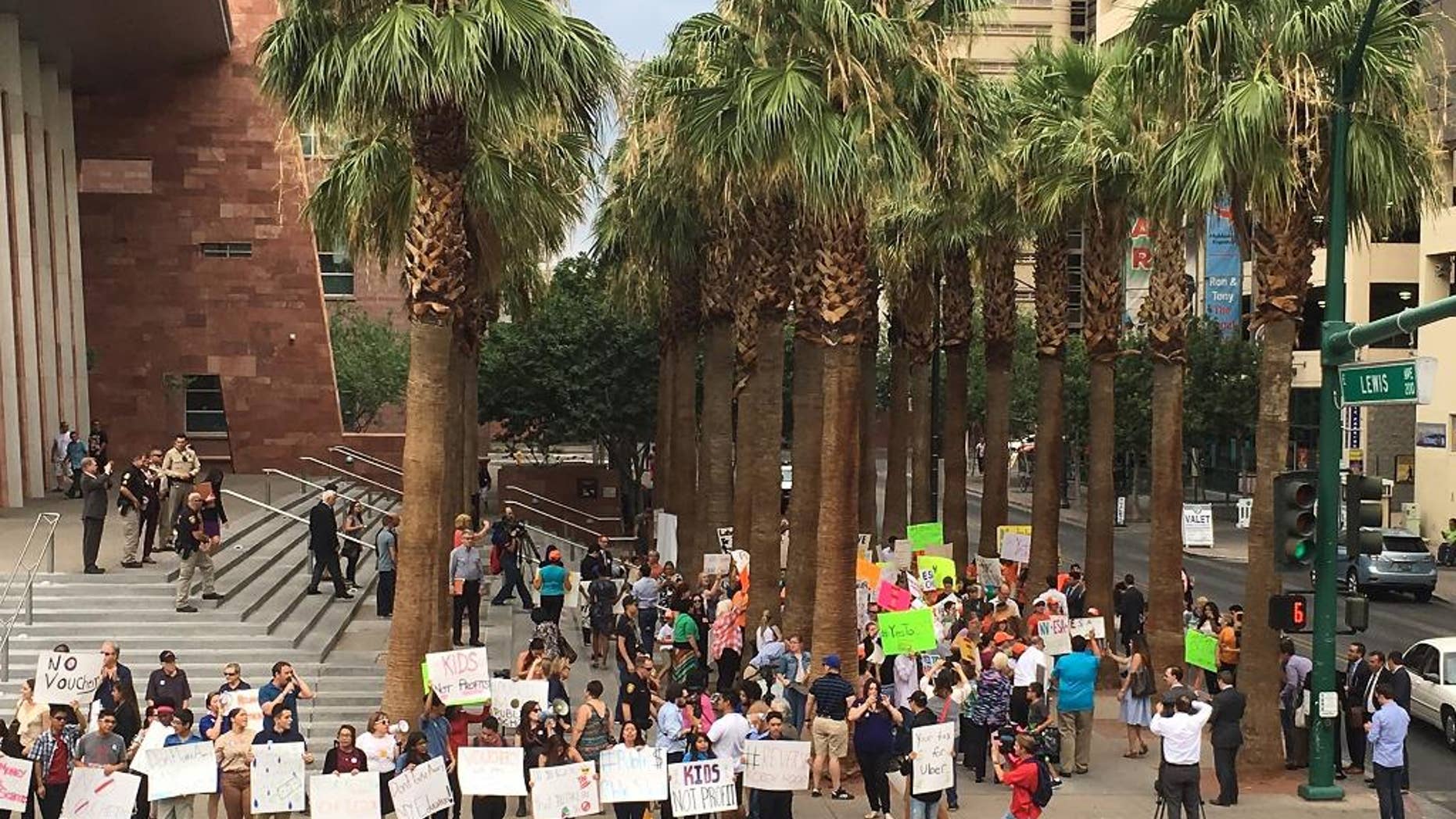 FILE - In this July 29. 2016 file photo, protesters for and against a sweeping Nevada school choice program voice their opinions about the measure being argued before the Nevada Supreme Court in Las Vegas. The Nevada Supreme Court has ruled that the state's voucher-style Education Savings Accounts program, seen as the broadest school choice initiative in the country, has an unconstitutional funding mechanism that should remain blocked. Justices issued a 4-2 ruling on Thursday, Sept. 29, 2016, against the money source for the program, which has been on hold since the winter and never disbursed funds to families as it intended, but upholding some of the major tenets underlying the school voucher concept. (AP Photo/Ken Ritter, File)