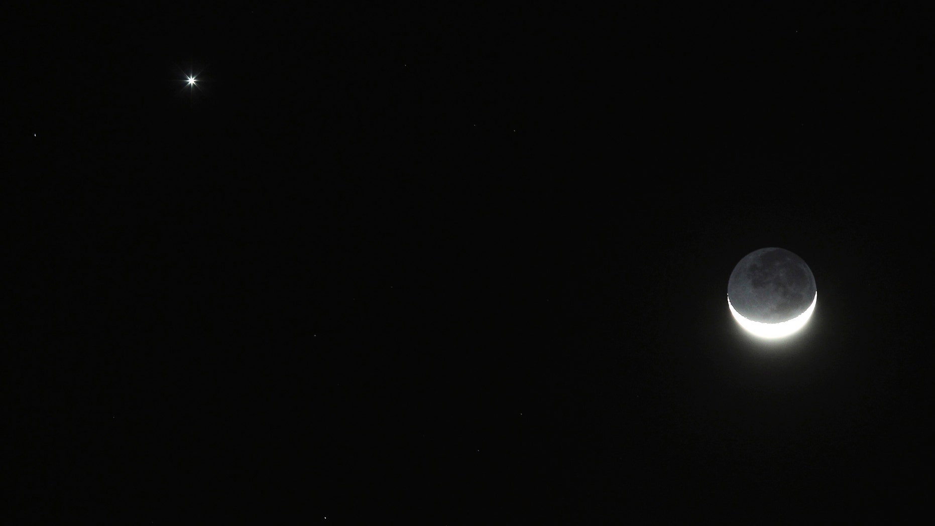 A crescent moon (R) is seen next to the planet Jupiter in the sky over Amman Februray 25, 2012. REUTERS/Ali Jarekji (JORDAN - Tags: SOCIETY) - RTR2YFYF