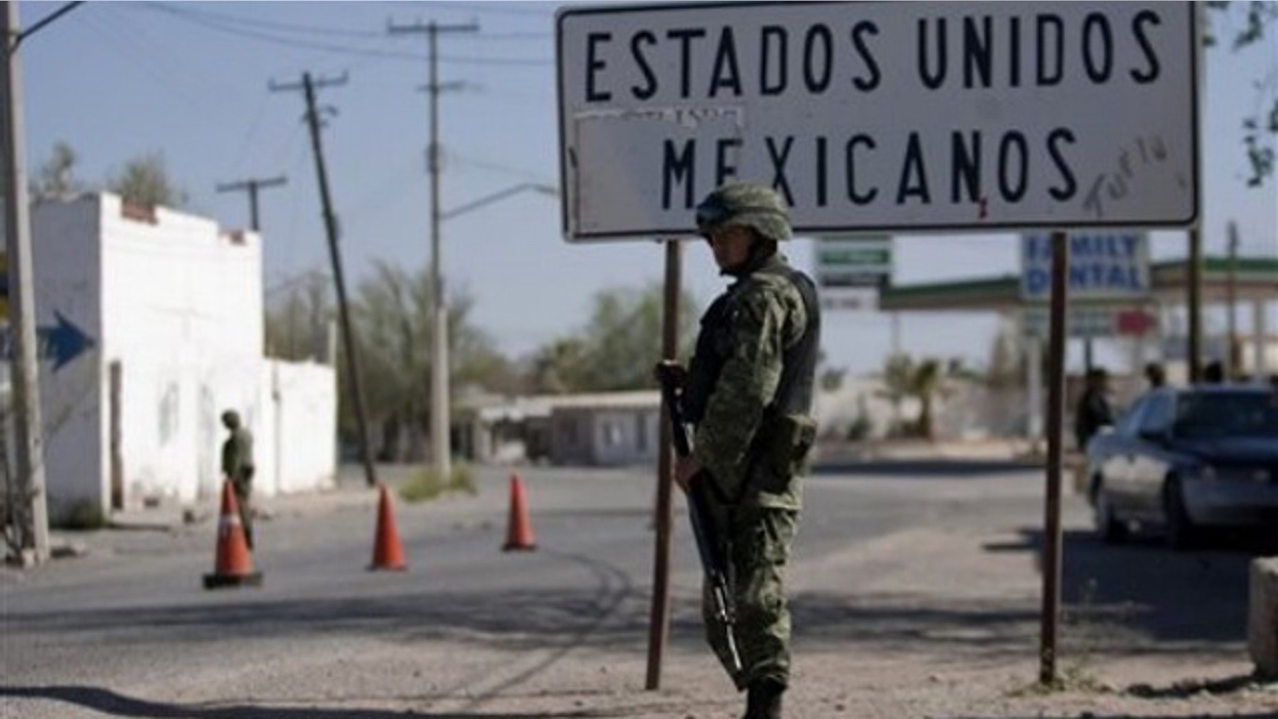 In this photo taken April 7, 2010, soldiers guard near the U.S.-Mexico border in Caseta border town, Valle de Juarez, northern Mexico. Hundreds of families are fleeing the cotton-farming towns of the Juarez Valley, a stretch of border 50 miles east of Ciudad Juarez. In a new strategy, Mexican drug cartels seeking to minimize interference with their operations are using terror to empty the entire area. (AP Photo/Guillermo Arias)