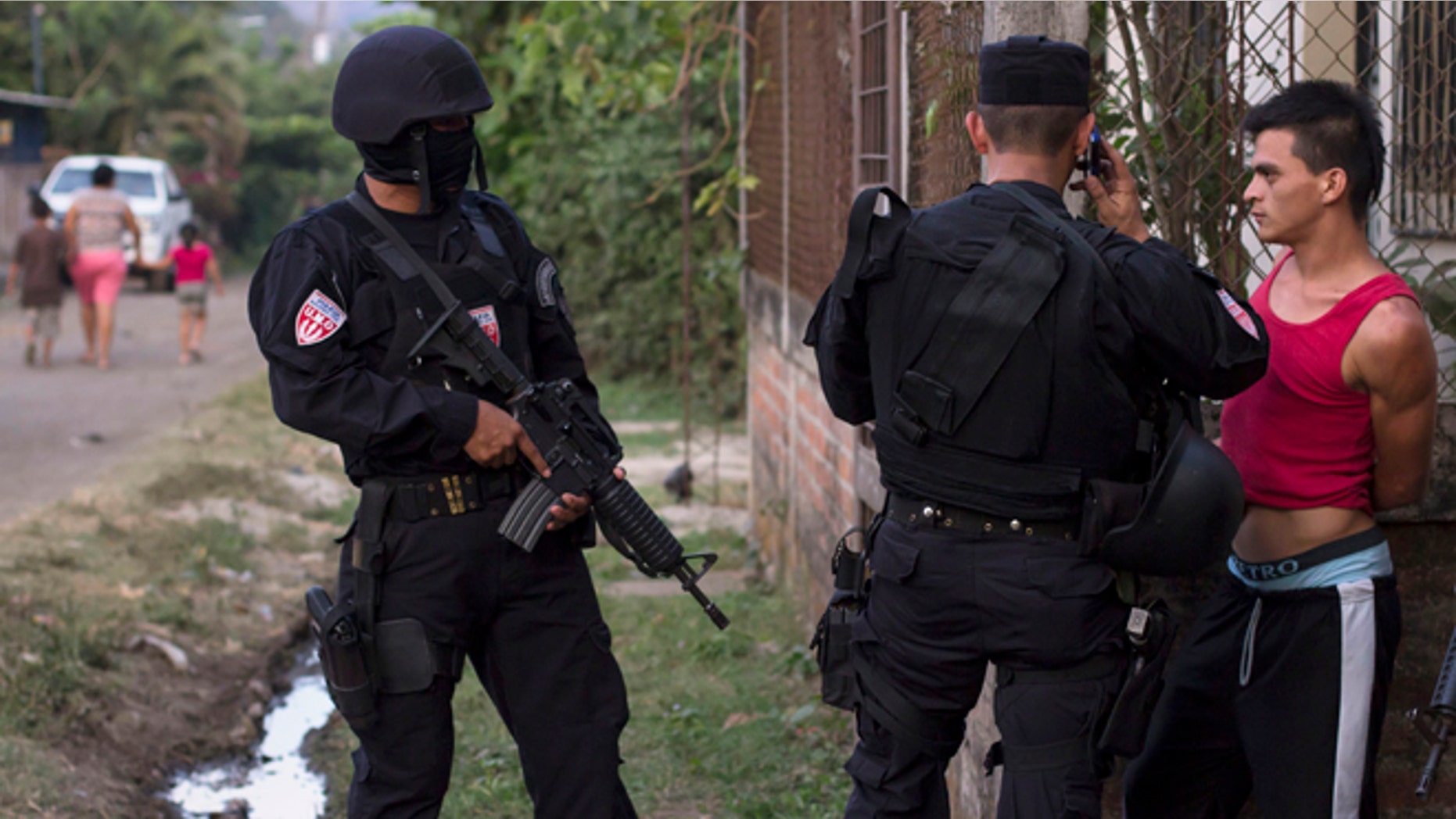 In this April 1, 2015 photo, a man is detained by police special forces in the town of San Juan Opico, El Salvador.
