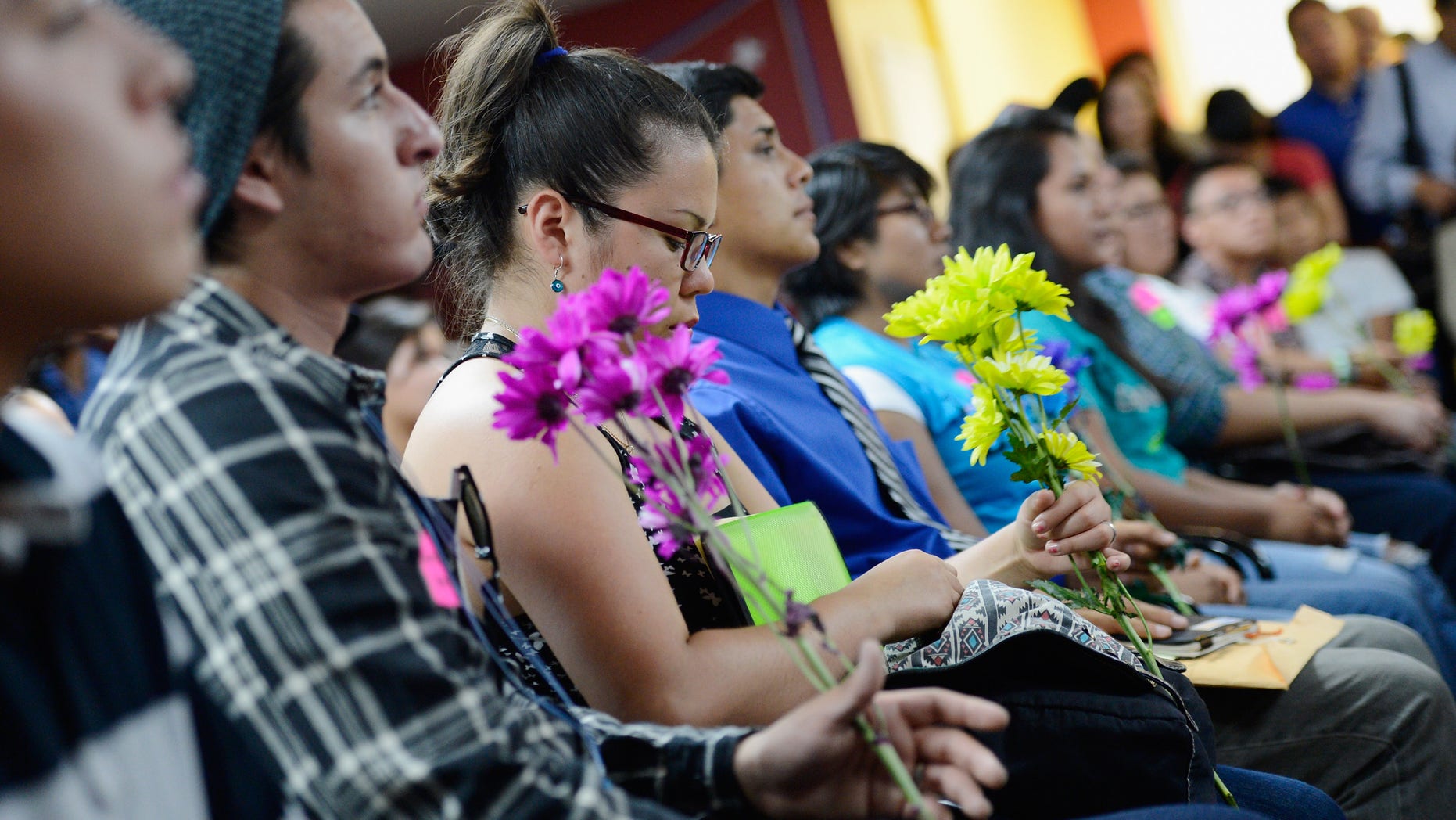 LOS ANGELES, CA - AUGUST 15: A group of immigrants, known as DREAMers, hold flowers as they listen to a news conference to kick off a new program called Deferred Action for Childhood Arrivals at the Coalition for Humane Immigrant Rights of Los Angeles on August 15, 2012 in Los Angeles, California. Under a new program established by the Obama administration undocumented youth who qualify for the program, called Deferred Action for Childhood Arrivals, can file applications from the U.S. Citizenship and Immigration Services website to avoid deportation and obtain the right to work (Photo by Kevork Djansezian/Getty Images)
