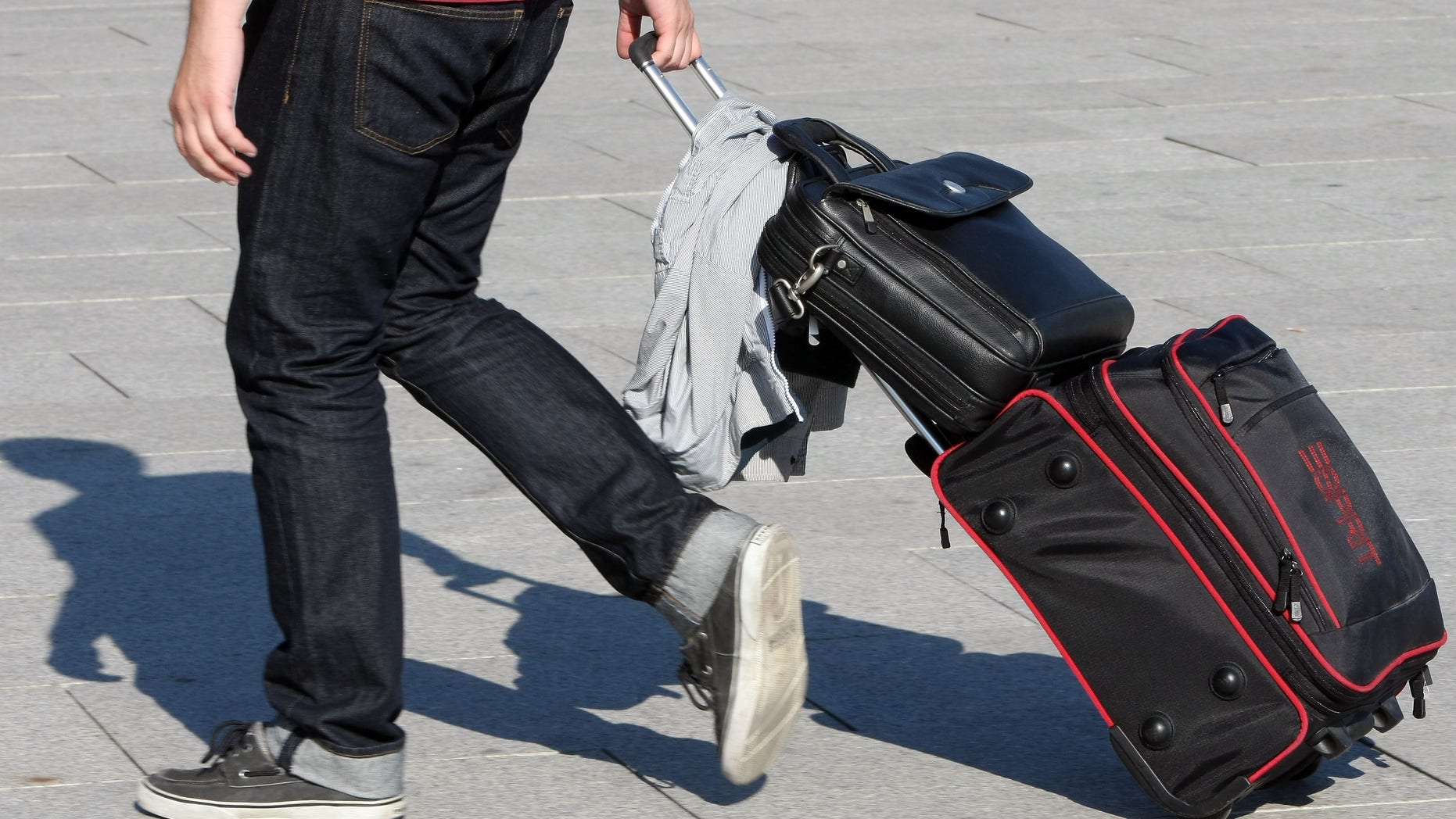 BERLIN, GERMANY - AUGUST 15: A tourist pulls a rolling suitcase on August 15, 2012 in Berlin, Germany. In 2010, nine million tourists visited the German capital, and ten million came in 2011, a new record. Tourism, a major industry for the city since the fall of the Berlin Wall, contributes 9 billion euros (USD 11.1 billion) into the local economy annually, and has a high employment impact, with 230,000 Berliners earning a living in the tourism sector. The increase in visitors is not limited to Berlin; 75 out of 80 German cities reported more tourists in 2011 over the previous year. (Photo by Adam Berry/Getty Images)