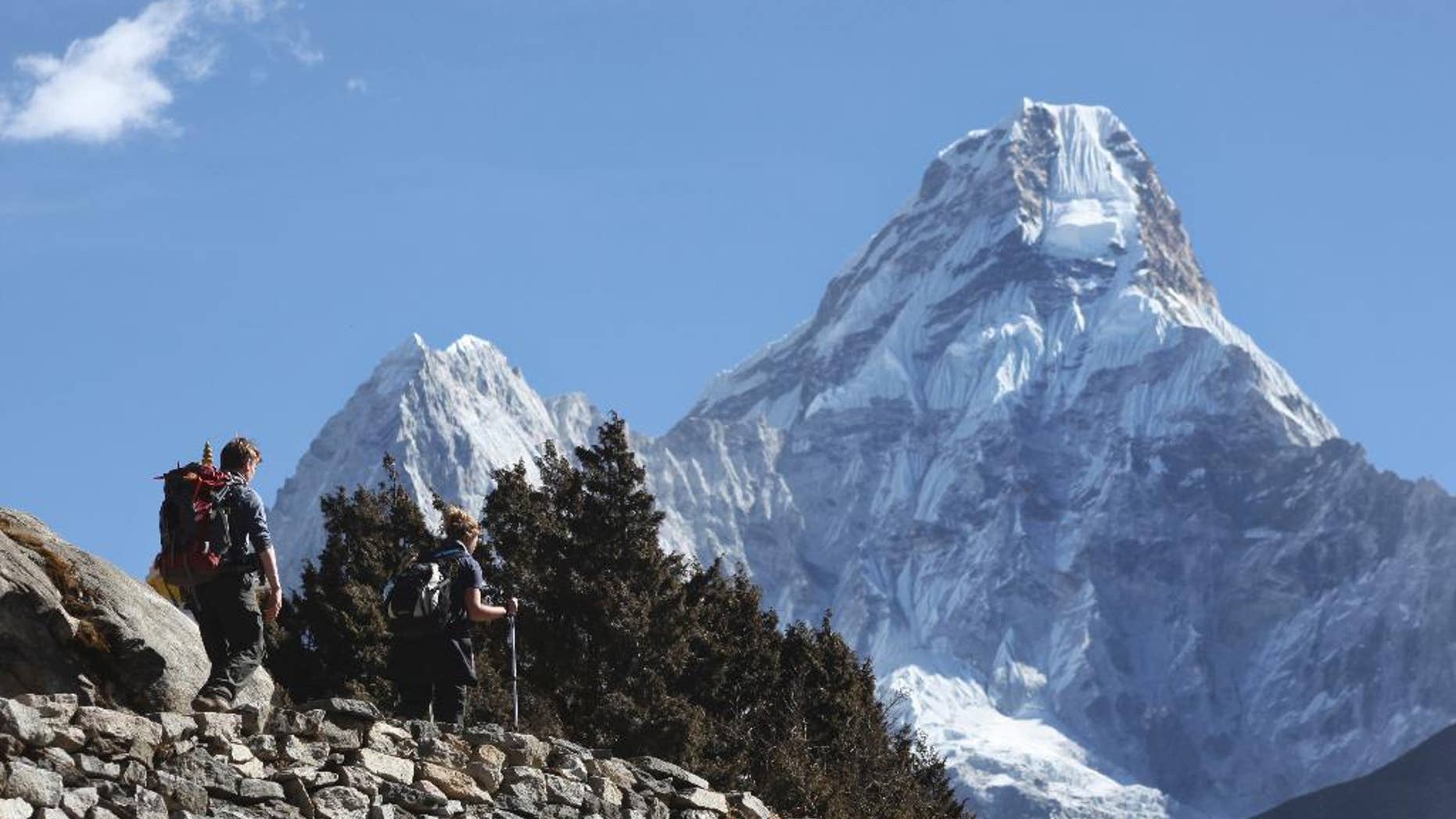 FILE - In this Feb. 19, 2016, file photo, trekkers make their way to Dingboche, a popular Mount Everest base camp, in Pangboche, Nepal. Officials say three foreign climbers; two British Kenton Cool, Robert Richard Lucas, and Mexican David Liano Gonzalez along with three Nepalese guides have scaled Mount Everest, the first foreigners to reach the summit in two years. (AP Photo/Tashi Sherpa, File)