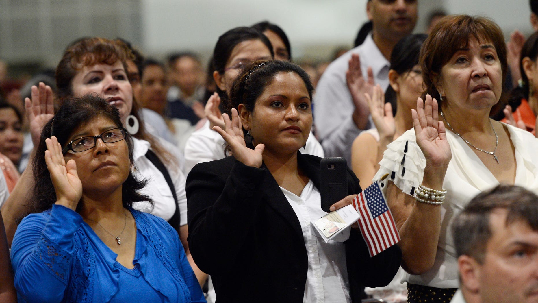 LOS ANGELES, CA - AUGUST 23: U.S. citizenship candidates take the oath of citizenship at a naturalization ceremony at the Los Angeles Convention Center on August 23, 2012 in Los Angeles, California. Nearly 7,800 candidates became citizens representing more than 100 countries. (Photo by Kevork Djansezian/Getty Images)