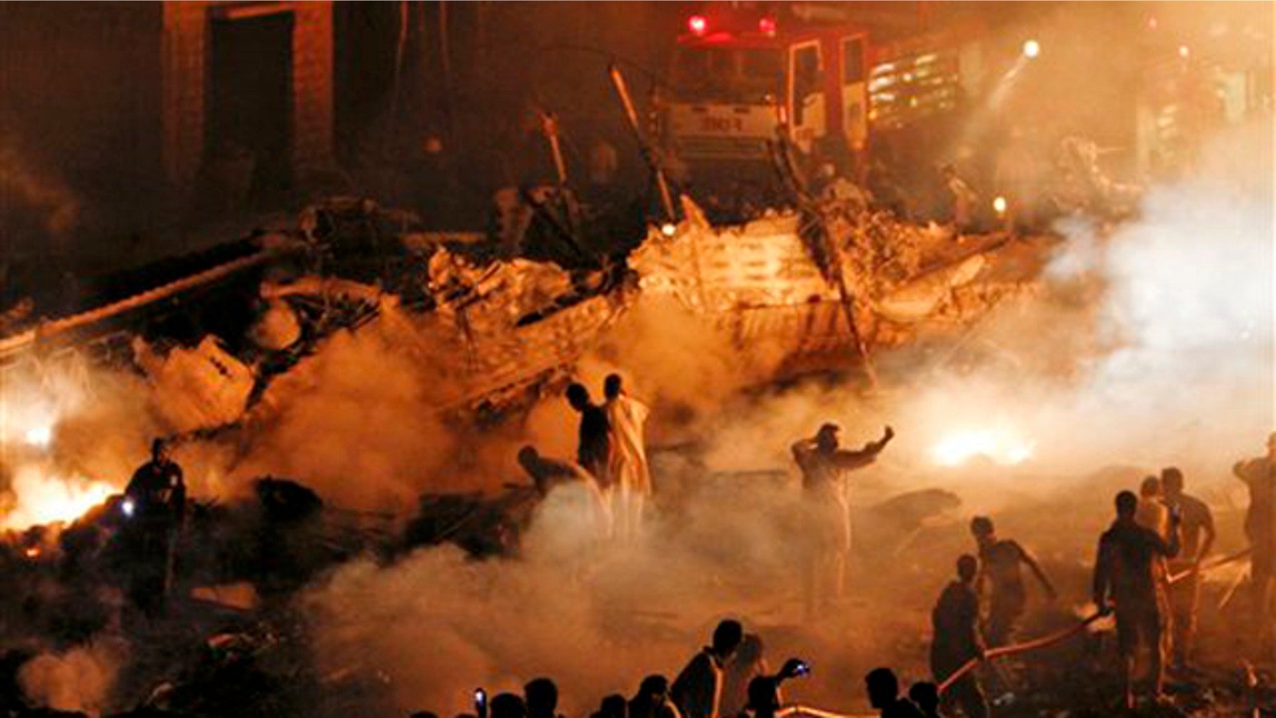 Pakistani volunteers and firefighters struggle to extinguish a fire at the site of a plane crash in Karachi, Pakistan on Sunday, Nov. 28, 2010. A cargo plane crashed into a housing complex in Pakistan's largest city soon after takeoff Sunday, setting off a huge blaze. The aircraft had eight crew on board, the civil aviation authority said.