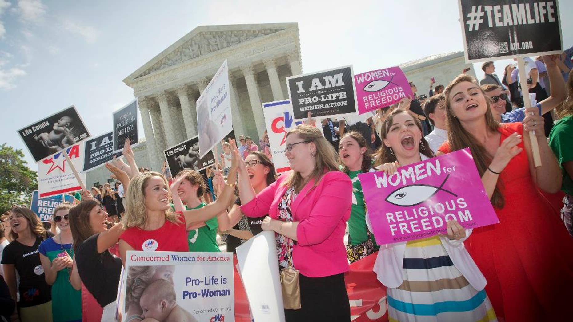 FILE - In this June 30, 2014 file photo, demonstrators react to hearing the Supreme Court's decision on the Hobby Lobby birth control case outside the Supreme Court in Washington. The Supreme Court rid itself Monday, May 16, 2016, of a knotty dispute between faith-based groups and the Obama administration over birth control. The court asked lower courts to take another look at the issue in a search for a compromise. (AP Photo/Pablo Martinez Monsivais, File)