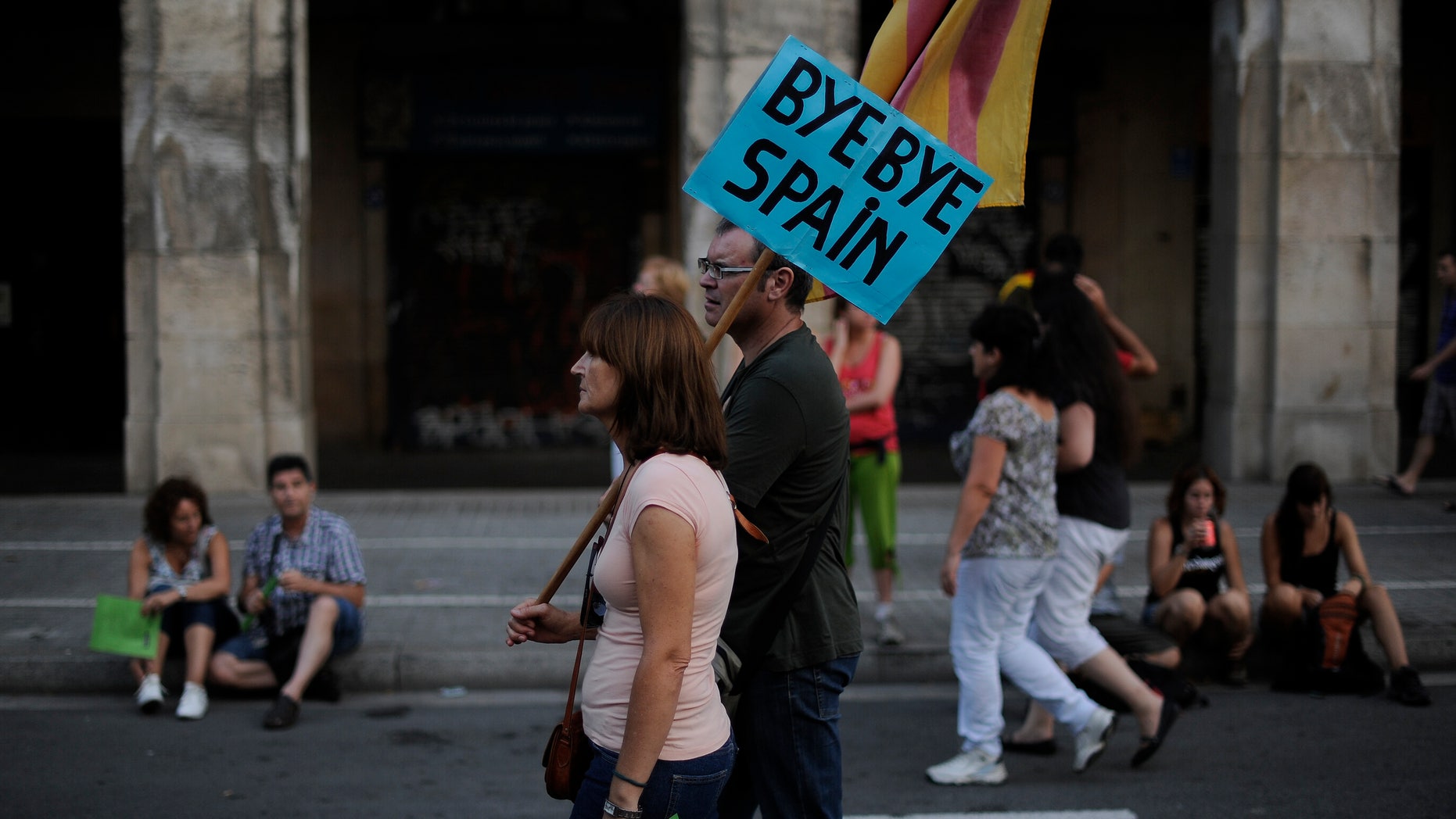 BARCELONA, SPAIN - SEPTEMBER 11: A couple holds a banner that reads 'Bye Bye Spain' during a demonstration calling for independence during the Catalonia's National Day on September 11, 2012 in Barcelona, Spain. Thousands of Catalans took to the streets of Barcelona demanding a split from Spain and control of their own economy under the slogan 'Catalonia: New European State' on Catalonia's National Day. The Diada Nacional is held every September 11 to remember the defeat of the Catalan troops in 1714. (Photo by David Ramos/Getty Images)