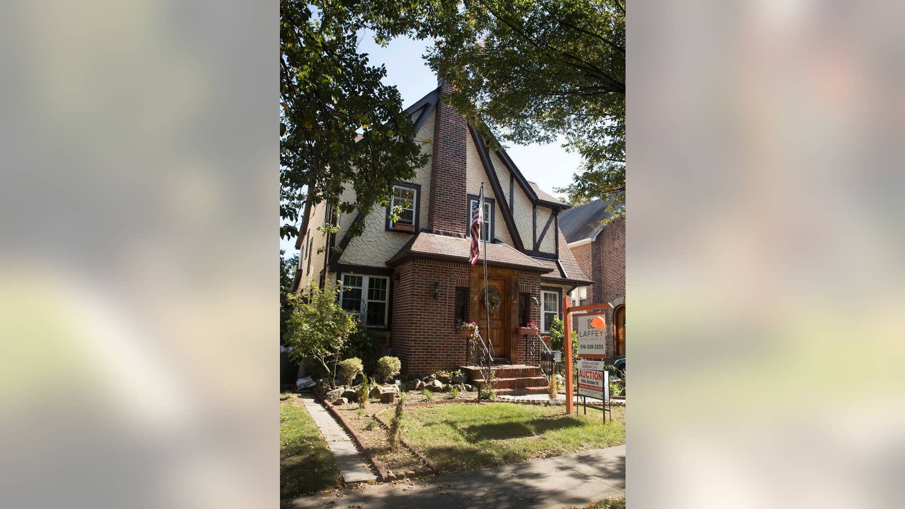 FILE - This Tuesday, Oct. 18, 2016 file photo, shows the exterior of a house in the Jamaica Estates neighborhood of the Queens borough of New York, where Republican presidential candidate Donald Trump spent his early childhood. Trump’s boyhood home in New York City is going back on the auction block. Paramount Realty said the 1940 Tudor-style house in Jamaica Estates in Queens is being offered Jan. 17, 2017. (AP Photo/Mary Altaffer, File)