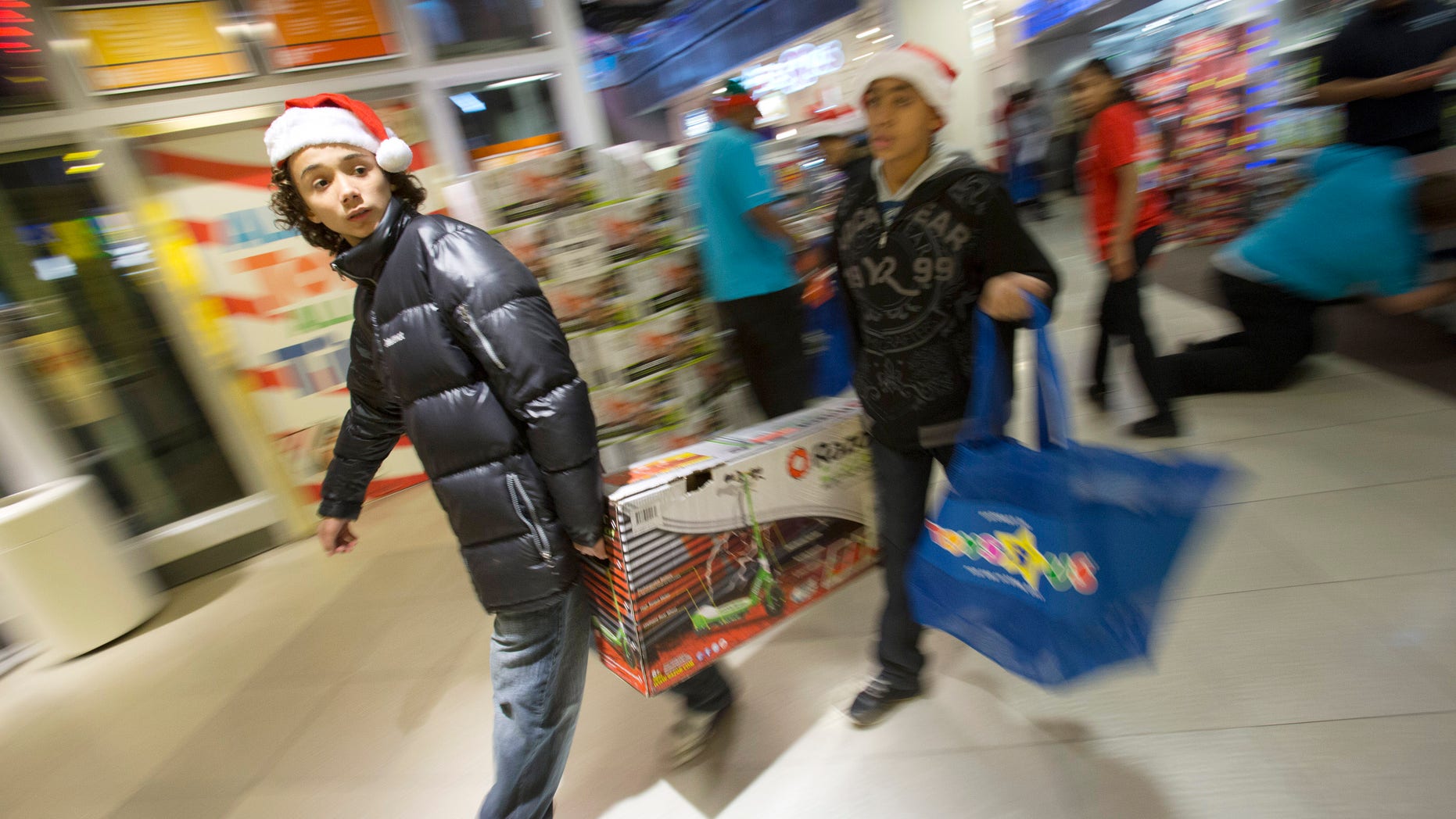 NEW YORK, NY - NOVEMBER 22: People carry items at the Black Thursday sale at the Toys 'R' Us store in Times Square November 22, 2012 in New York City.The store got a head start on the traditional Black Friday sales by opening their doors at 8pm on Thanksgiving night. (Photo by Andrew Kelly/Getty Images)