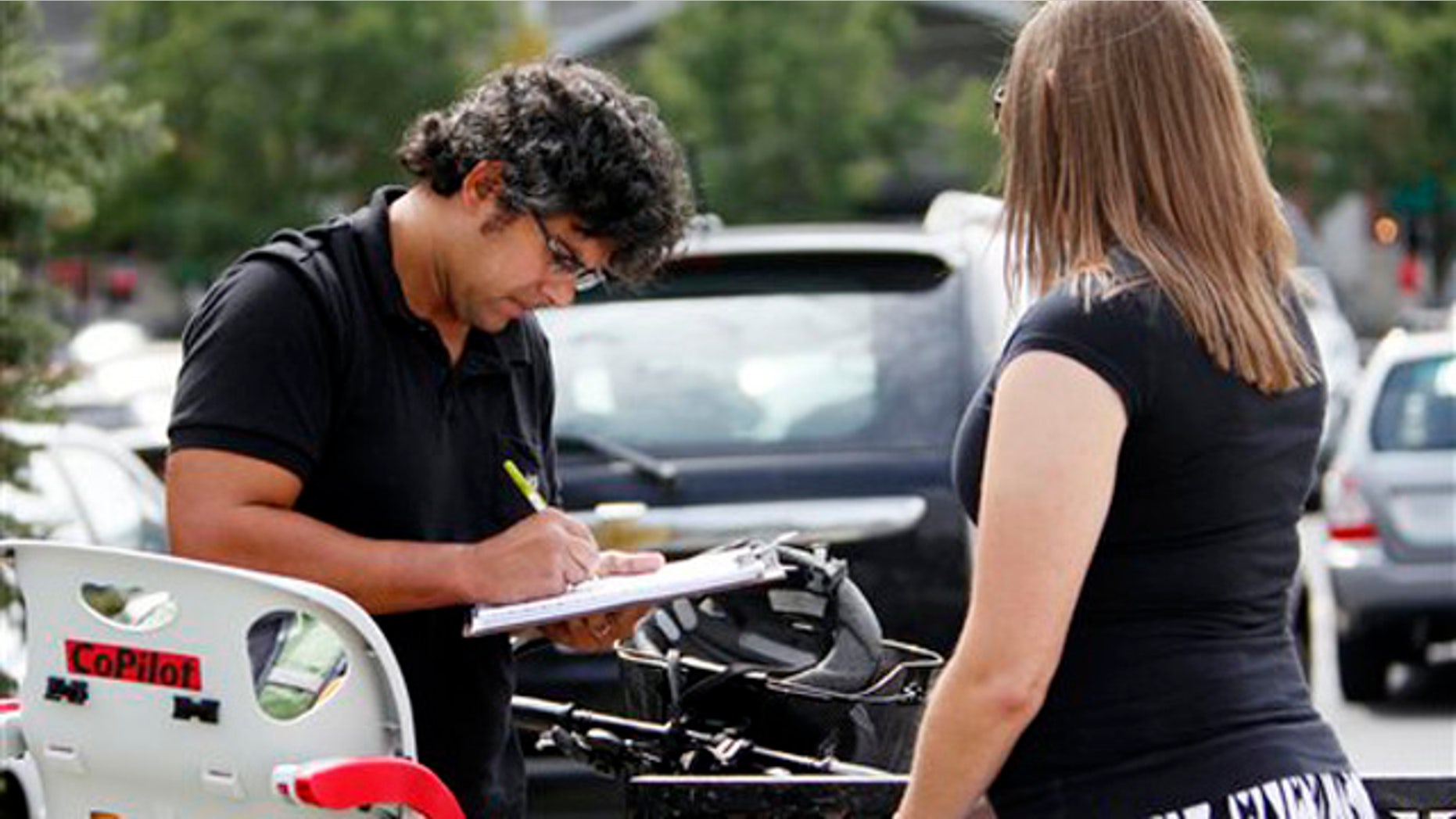 In this Sept. 9, 2011, photo, Mellissa Brown, right, a volunteer for Organizing for America, collects a signature from Jay Gupta for a petition in Columbus, Ohio, in a ballot repeal effort by opponents of the Ohio's new elections law.