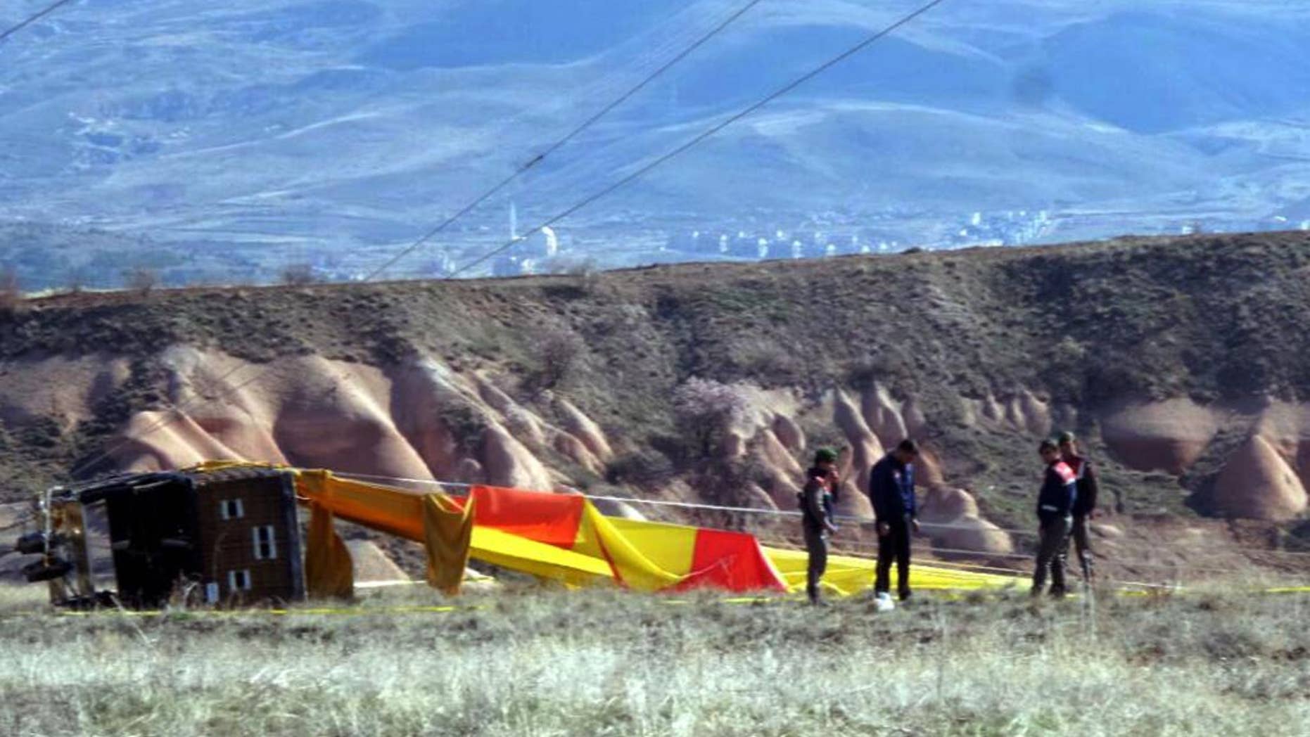 Security members investigate at the site after a hot air balloon hit a high-voltage transmission line and crashed near Cappadocia, a popular tourist destination in central Turkey, Sunday, April 9, 2017.