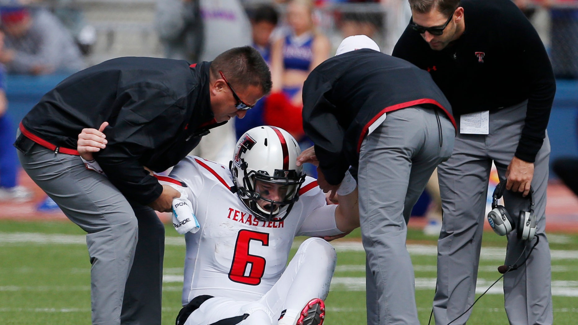 Texas Tech quarterback Baker Mayfield (6) is helped from the field by trainers and coach Kliff Kingsbury, right, during the second half of an NCAA college football game against Kansas in Lawrence, Kan., Saturday, Oct. 5, 2013. (AP Photo/Orlin Wagner)