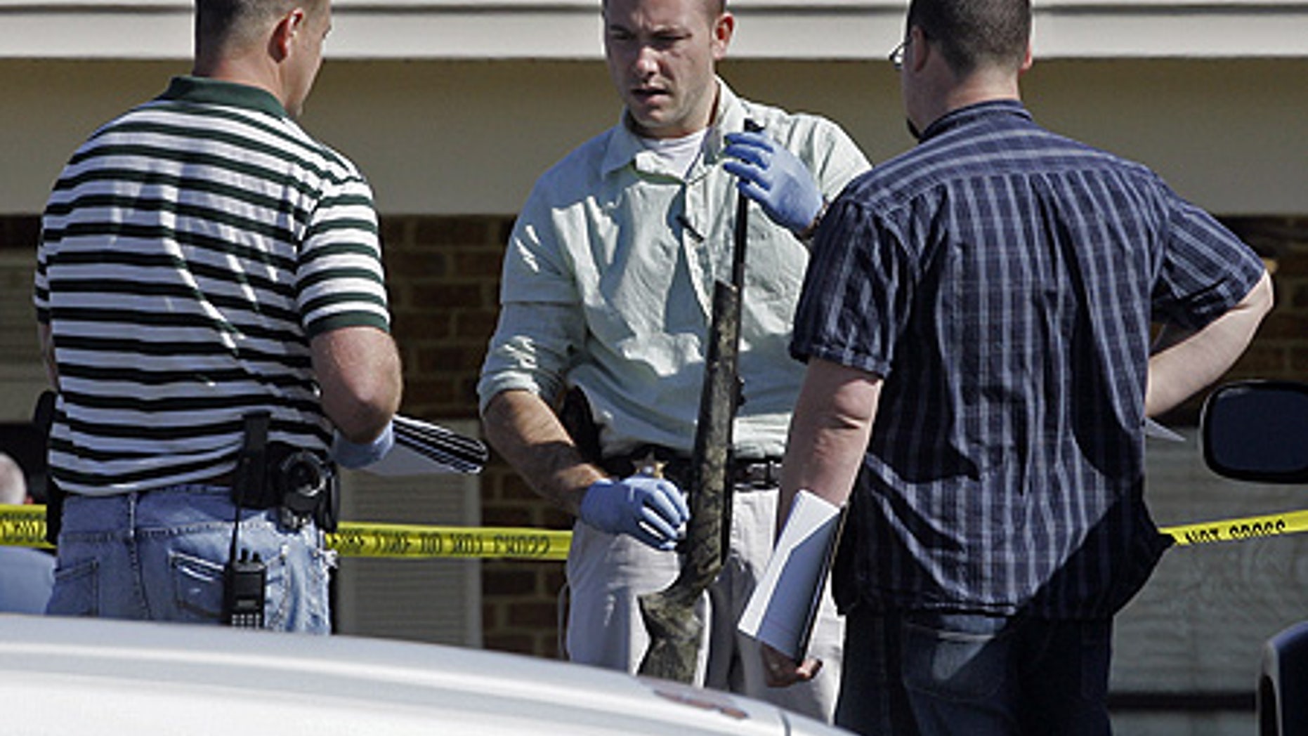 Mar. 29: Investigators examine a weapon at the scene where a gunman opened fire at a nursing home.