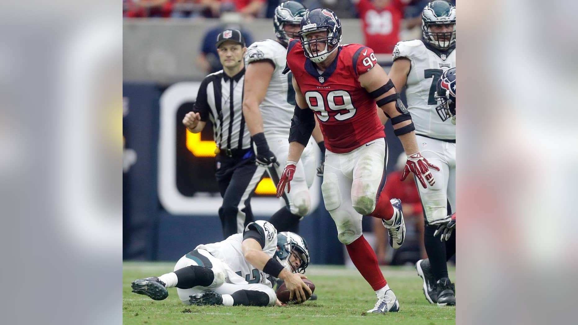Philadelphia Eagles quarterback Mark Sanchez, left, slowly gets up after being sacked 7-yard loss by Houston Texans defensive end J.J. Watt, right, during the second quarter of an NFL football game, Sunday, Nov. 2, 2014, in Houston. (AP Photo/Patric Schneider)