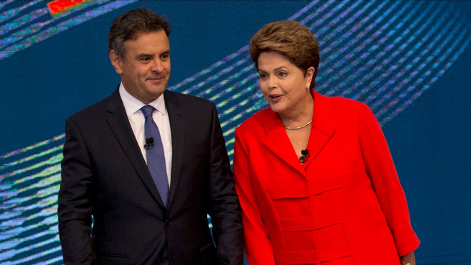 Brazil's incumbent President and Workers Party presidential candidate Dilma Rousseff, right, and challenger Aecio Neves, presidential candidate of the Brazilian Social Democracy Party, arrive on stage for the start of their presidential debate, in Rio de Janeiro, Brazil, Friday, Oct. 24, 2014. Rousseff and Neves are in a tight election contest, that culminates Sunday when millions of Brazilians are expected to go to the polls and decide who'll be the next leader of Latin America's biggest economy. (AP Photo/Silvia Izquierdo)